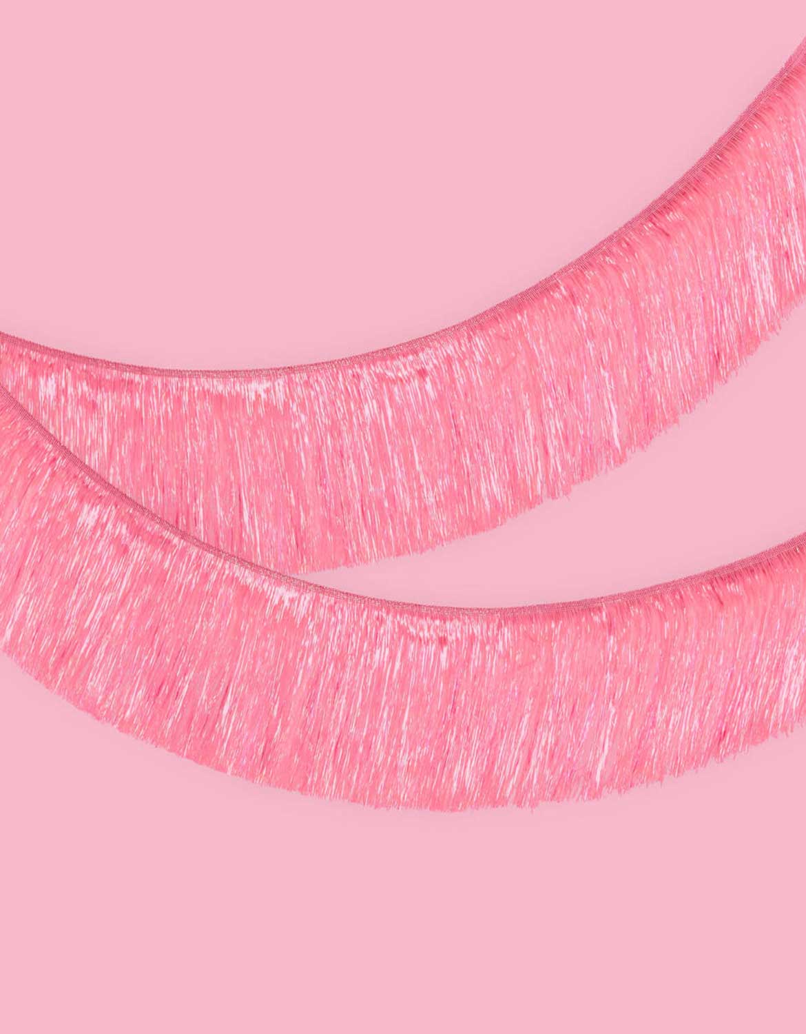 Momo Party's 5 ft Bright Pink Fringe Garland on a pink background.