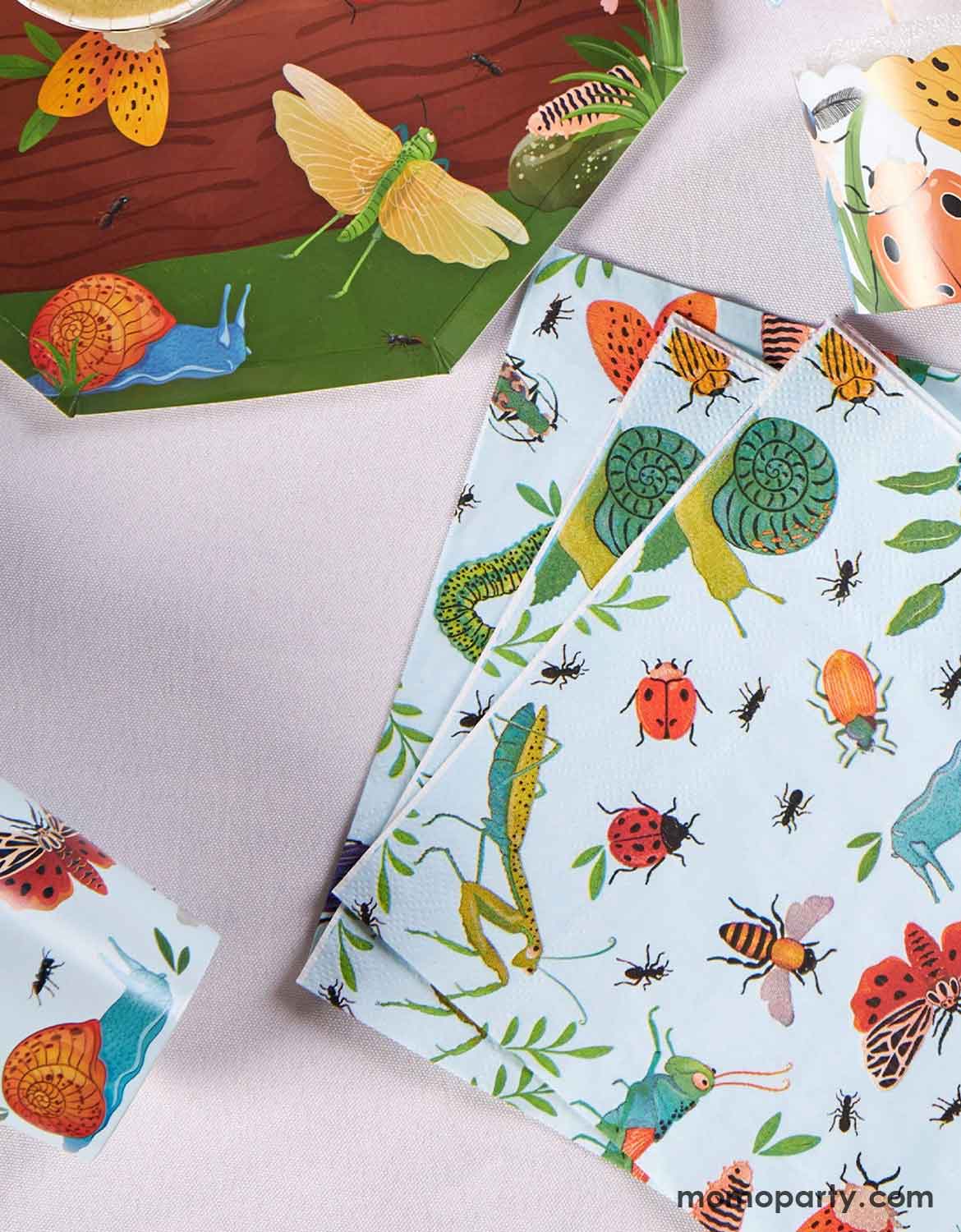 Momo Party's Insect-themed party napkins, cups and plates on a white table.