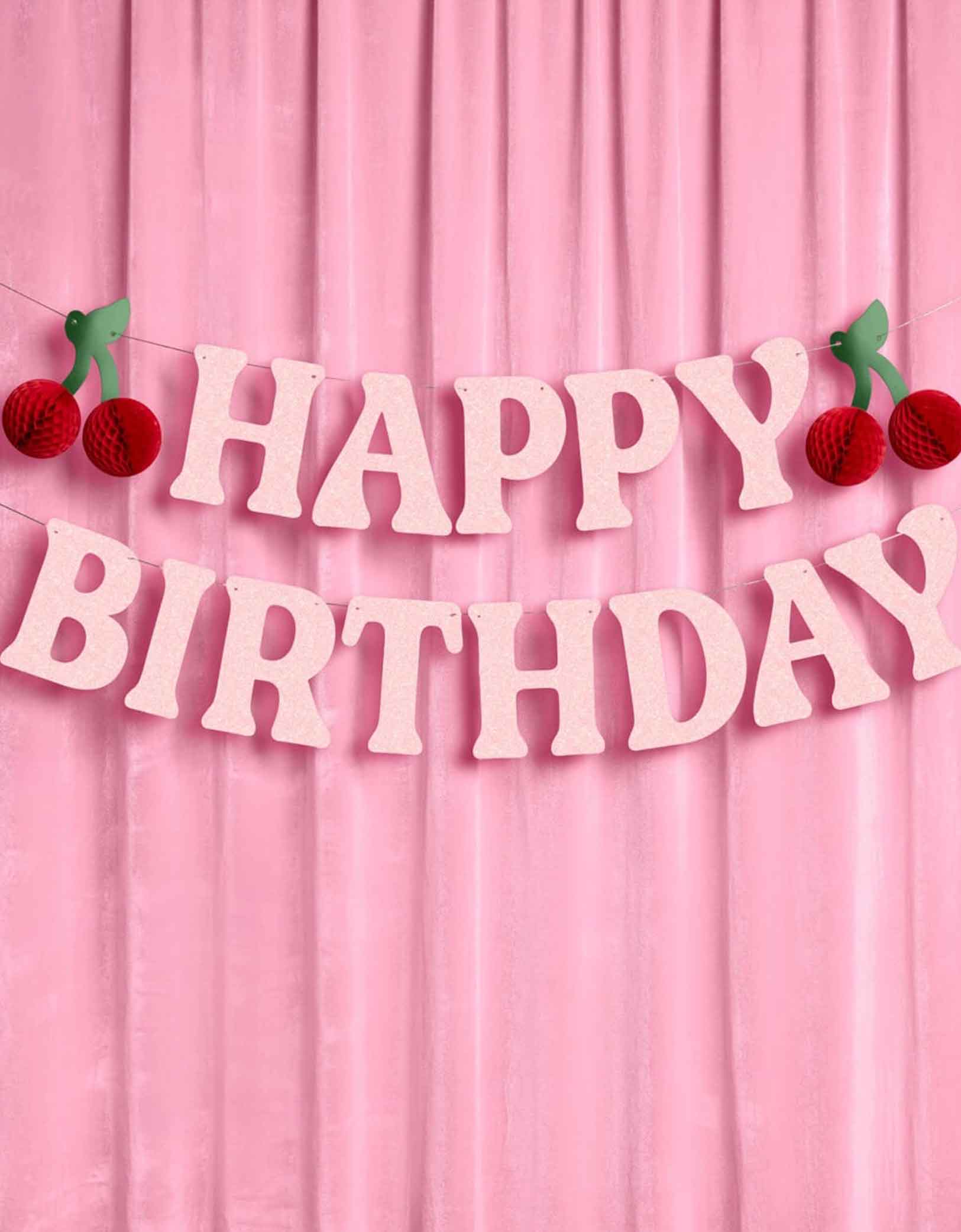 Momo Party's 4.5' cherry happy birthday banner hung against a pink curtain.
