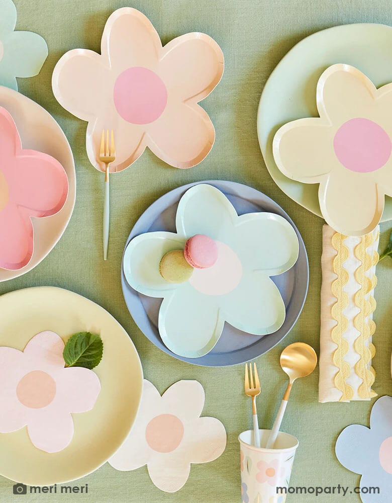 A spring party table featuring Momo Party's daisy shaped plates and napkins in multiple pastel colors, with pastel colored round table, it makes a charming tablescape for a spring gathering, kid's daisy themed birthday or an Easter celebration.