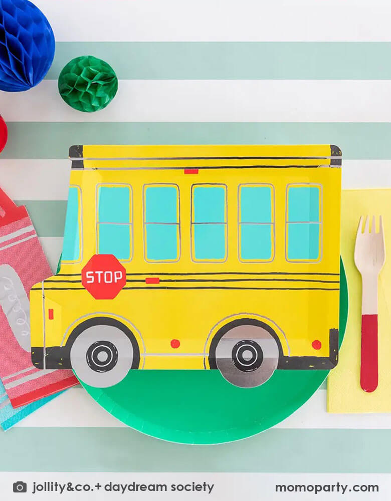 A festive back to school party featuring Momo Party's colorful school themed tableware including Daydream Society's school bus shaped plates, crayon shaped napkins with bright colored round plates and party cups. With festive colored honeycomb decorations on the party table, this gives a great idea and inspiration for a kid's back to school celebration.