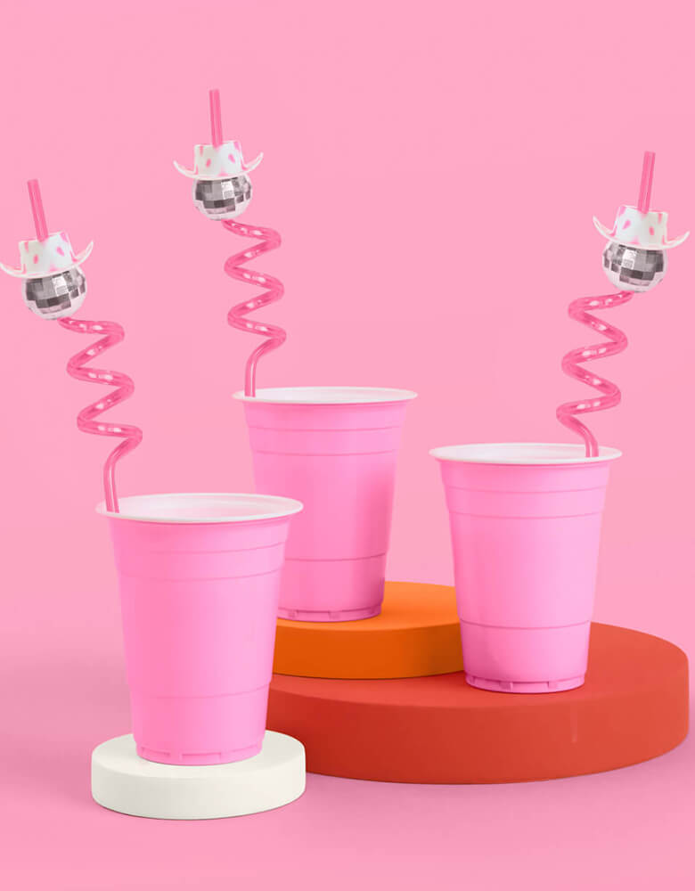 Momo Party's 10" reusable disco cowgirl swirly straws by Xo, fetti in pink solo cups. These disco cowgirl straws with a cowgirl hat on them are perfect for rodeo themed birthday parties or bachelorette parties. Yeehaw!