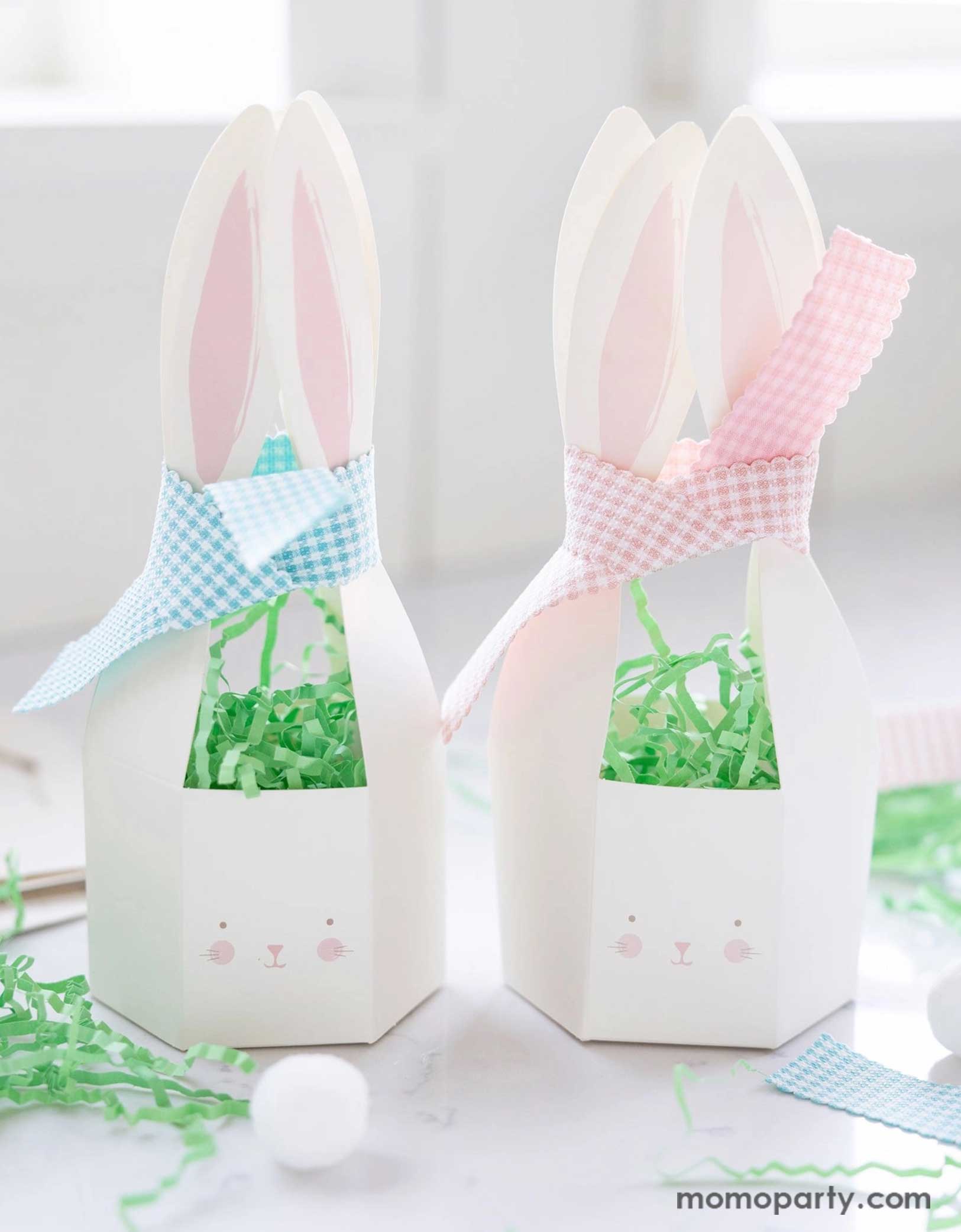 Momo Party's 8" x 7" Bunny Treat Boxes by My Mind's Eye. Comes in 10 paper boxes with two colors ribbons of gingham checkered pink and blue, tied on the top. These treat boxes are ideal for holding goodies for kids, these boxes bring a fun element to your Easter celebrations.
