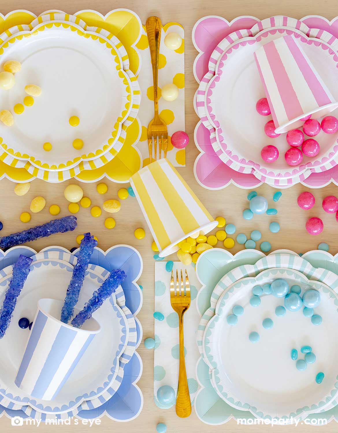 An overhead shot of Momo Party's colorful paper plates, cups and napkins with color-coordinated decorative elements and treats in yellow, pink, blue and mint colors on a wooden table.