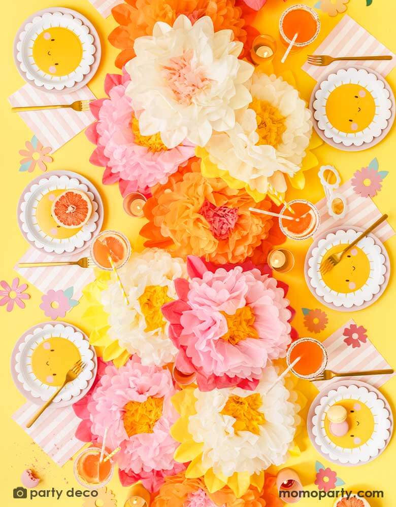 A cheerful "Flower Power" themed table decoration features Momo Party's sunflower sunny scallop edged round plates, pink and white striped large napkins and cream and pink tissue paper flower decorations in the middle as centerpiece. Around the table you can see some flower paper cutouts scattered as decorations, with some macarons, sweet desserts, grapefruits and juice, this makes a great idea for kid's "You're my sunshine" themed party or any "Good Vibes" themed celebration!