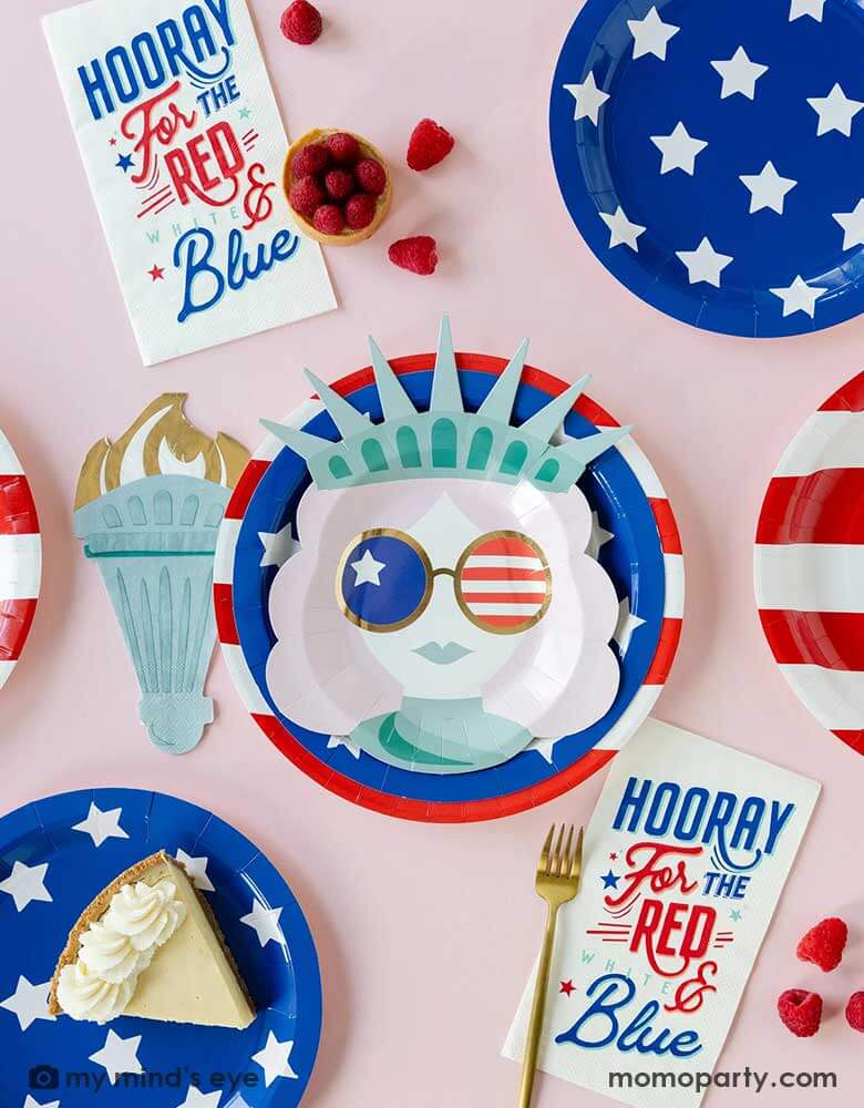 Momo Party's Lady Liberty party collection by My Mind's Eye featuring 10" red striped round plates, 9" blue star round plates, lady liberty shaped plates, torch shaped napkins and Hooray for the red white and blue dinner napkins, perfect for a modern Fourth of July party table for family and kids.
