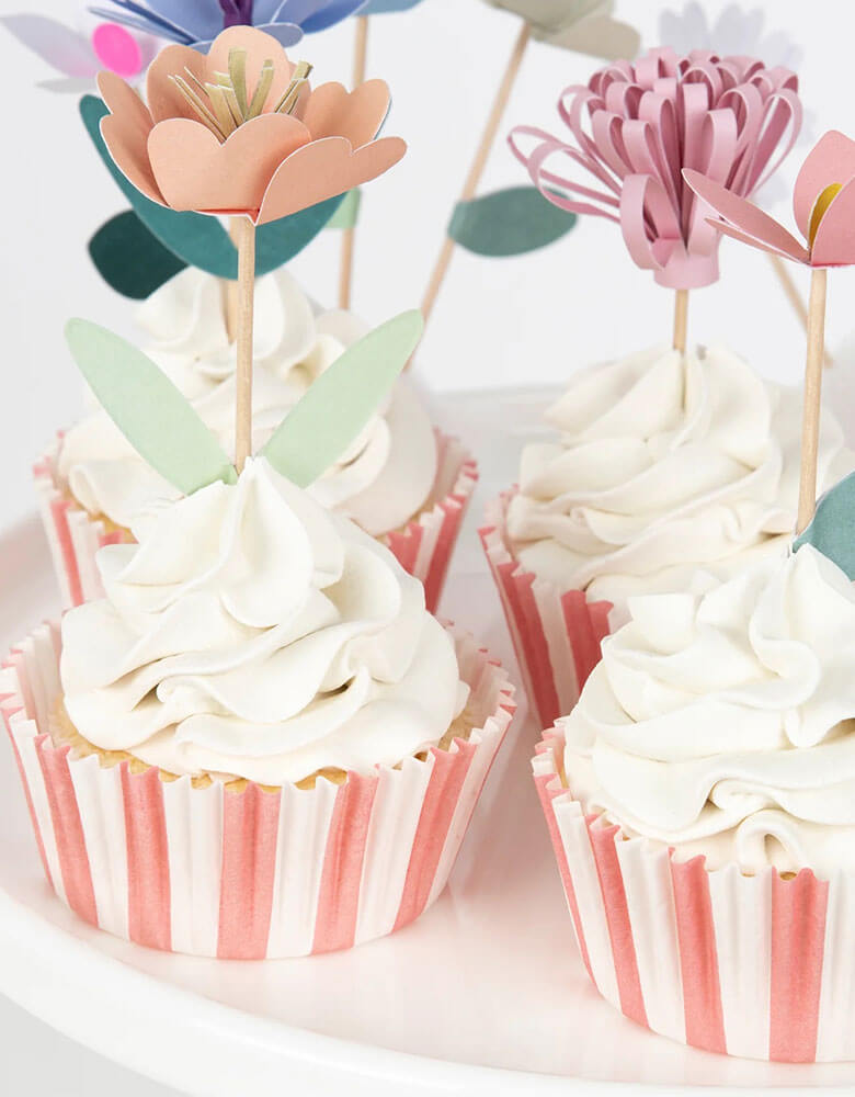 A close up of cupcakes decorated with Momo Party's flower garden cupcake kit which features beautiful hand crafted flowers toppers and striped cupcake cases, this gorgeous cupcake kit is a perfect addition to your spring inspired celebration or garden, floral themed birthday party.