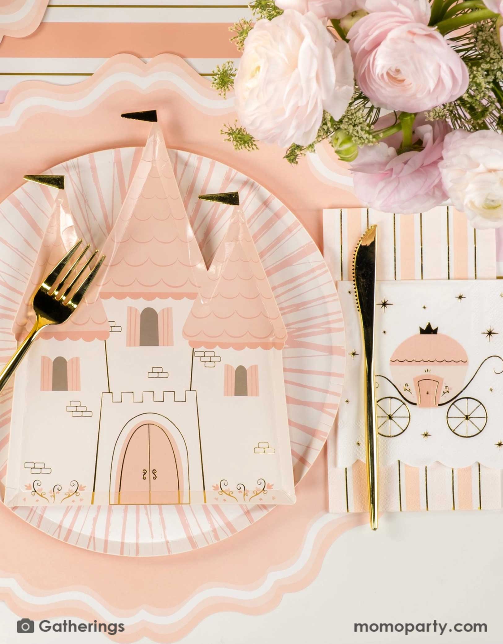 A beautiful princess themed table setting with the castle shaped plate, princess carriage small napkin, gold cutlery, and the pink and gold striped table runner, pink beautiful floral bouquet on the table, this creates a fairy tale tablescape for a girl's princess themed birthday party.