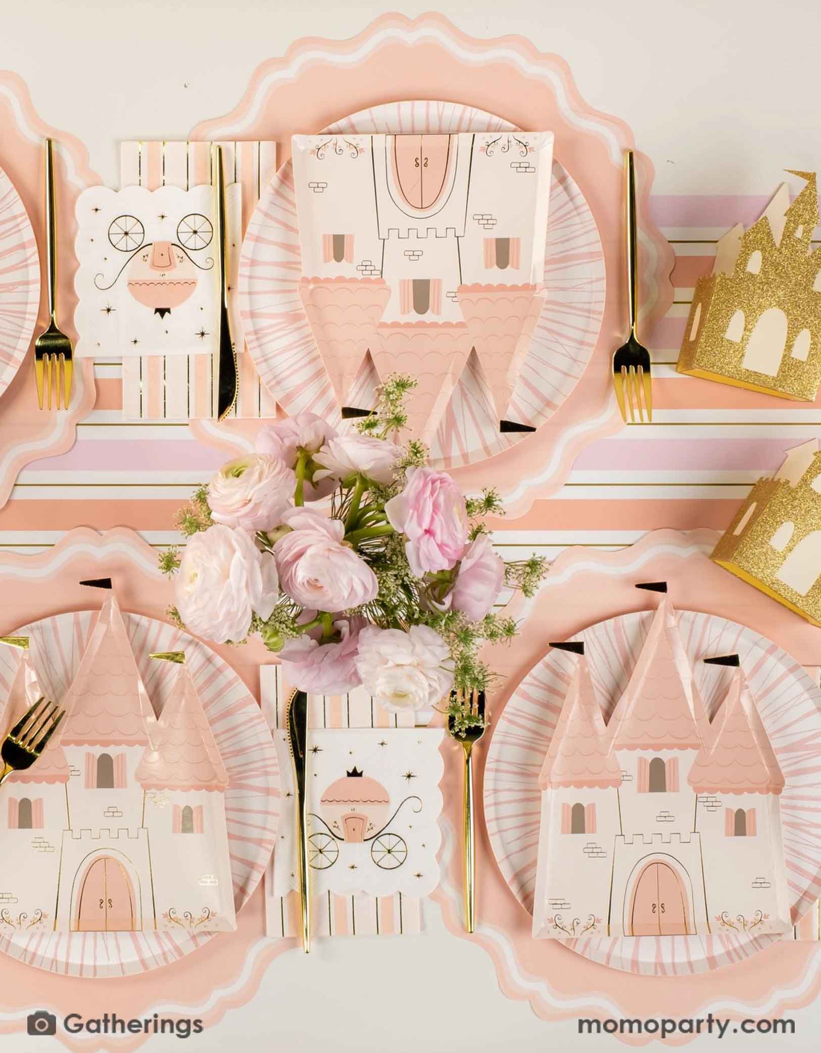 A beautiful princess themed table setting with the castle shaped plates, princess carriage small napkin, gold cutlery, castle shaped treat boxes and the pink and gold striped table runner from Momo Party. With a beautiful floral bouquet on the table, this creates a fairy tale tablescape for a girl's princess themed birthday party.