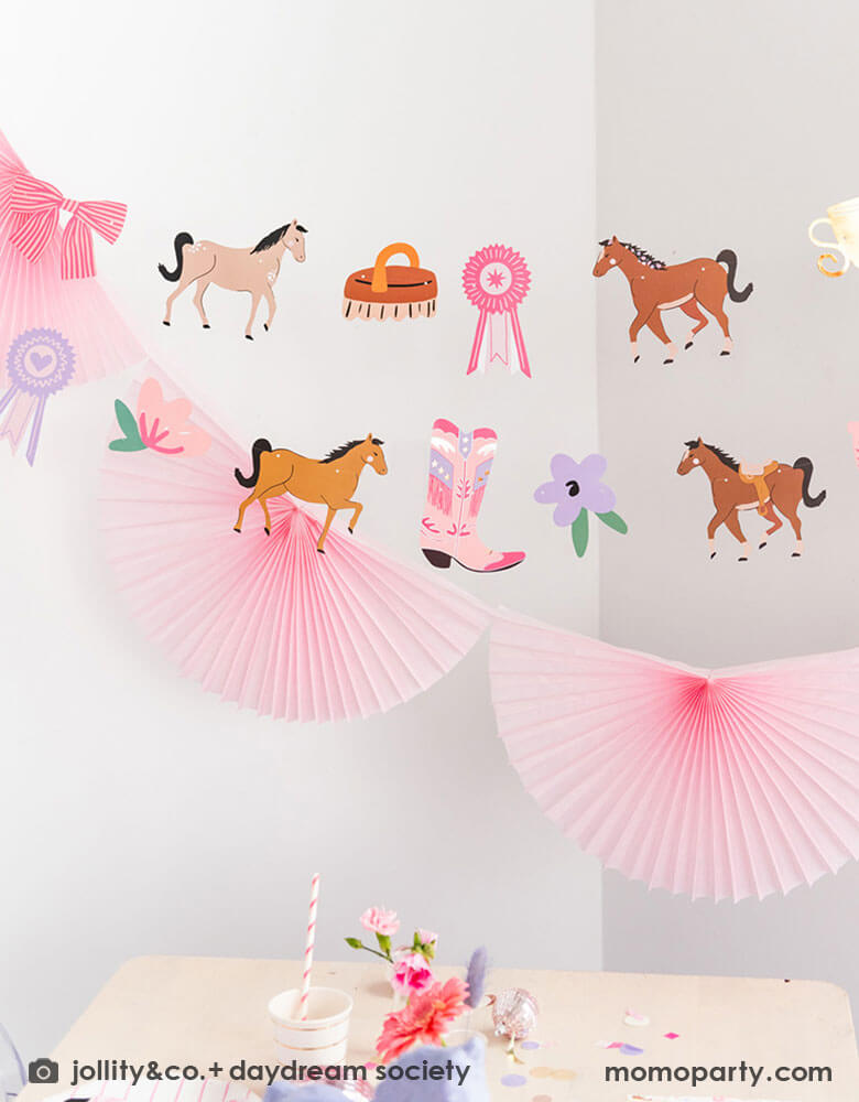 Momo Party's 20' pink cowgirl party garland by Daydream Society. Comes in 16 paper pennants with pink cowgirl rodeo themed elements including ponies, horse brushes, cowgirl boots, show ribbons, pink horseshoes, a bow and some flowers. This adorable party garland set is all you need to transform your girly party into the wild west!