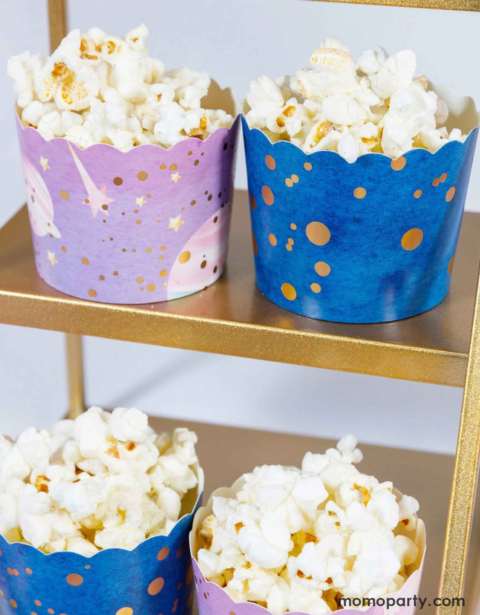 Popcorn in Momo Party's colorful space galaxy themed food cups on a gold cupcake stand.