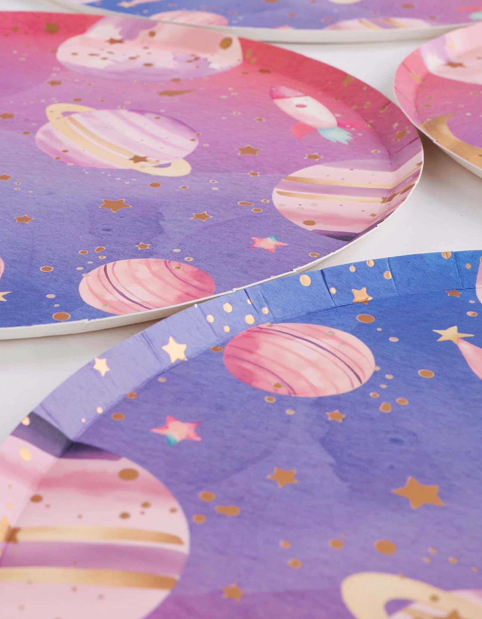 A closeup shot of Momo Party's 10" round lilac and pink ombre plate with space-themed design featuring planets and stars on a white background.