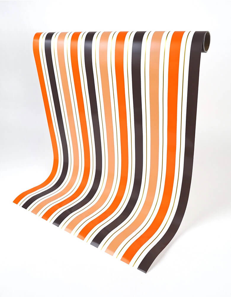 Momo Party's 18" 120" Halloween Stripe Paper Table Runner by Gatherings. Featuring bold orange and black stripes, this table runner is the perfect way to give your space a festive look. Get ready to bewitch your guests with its wicked style! Add a ravishing look to your table top with our uniquely created table runners, making your table appear more lavish. This table runners is 100% recyclable which helps with a swiftly cleaning process.