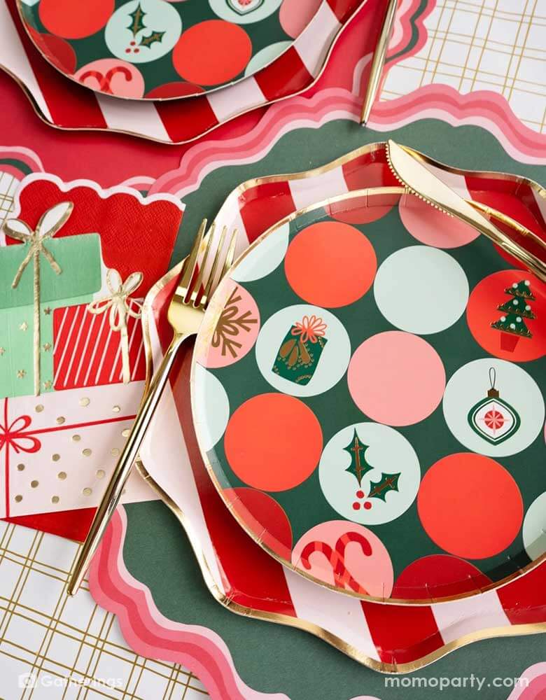 A festive Christmas party tablescape featuring Momo Party's Holiday tableware collection including red striped dinner plates and Christmas icon patterned side plates, along with gifts shaped napkins and red and green placemats, this makes a jolly table setting for this Holiday season.