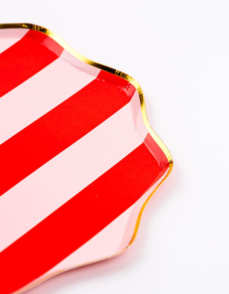 A close up shot of Momo Party's 10.5" Holiday Red Stripes Dinner Paper Plates by Gatherings. Comes in a set of 8 plates, made with eco-friendly FSC Mix paper, these vibrant and stylish plates with gold scallop edge are perfect for parties and dinners, making your tabletop a sight to behold. Create a festive atmosphere and elevate your dining experience with these plates!