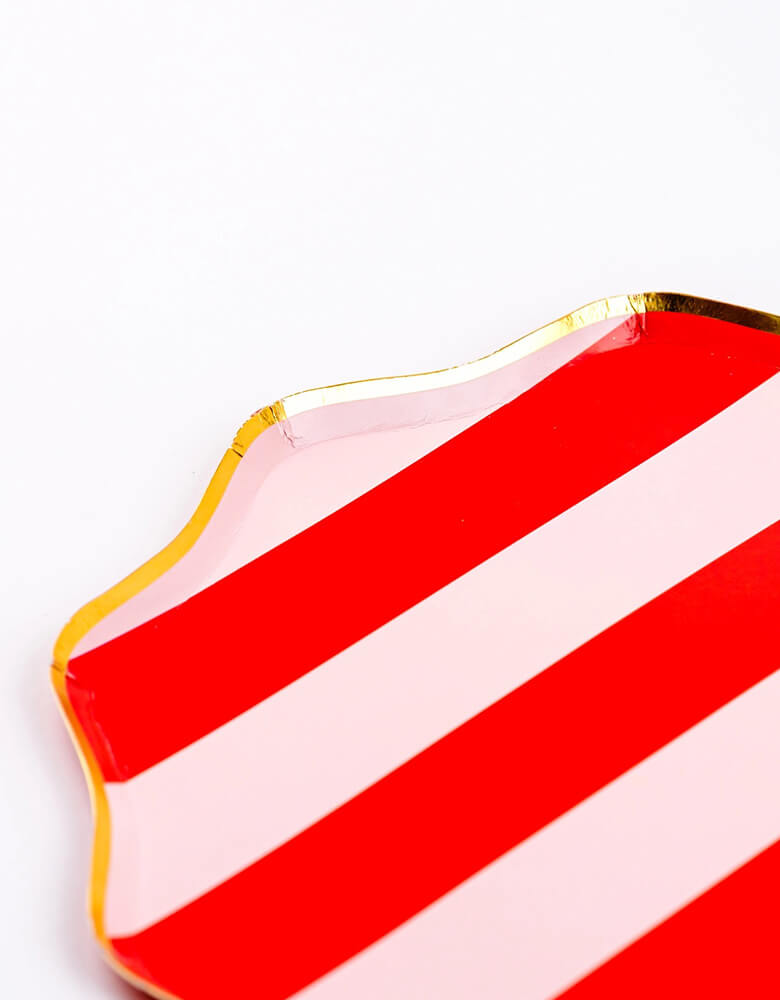 A close up shot of Momo Party's 10.5" Holiday Red Stripes Dinner Paper Plates by Gatherings. Comes in a set of 8 plates, made with eco-friendly FSC Mix paper, these vibrant and stylish plates with gold scallop edge are perfect for parties and dinners, making your tabletop a sight to behold. Create a festive atmosphere and elevate your dining experience with these plates!