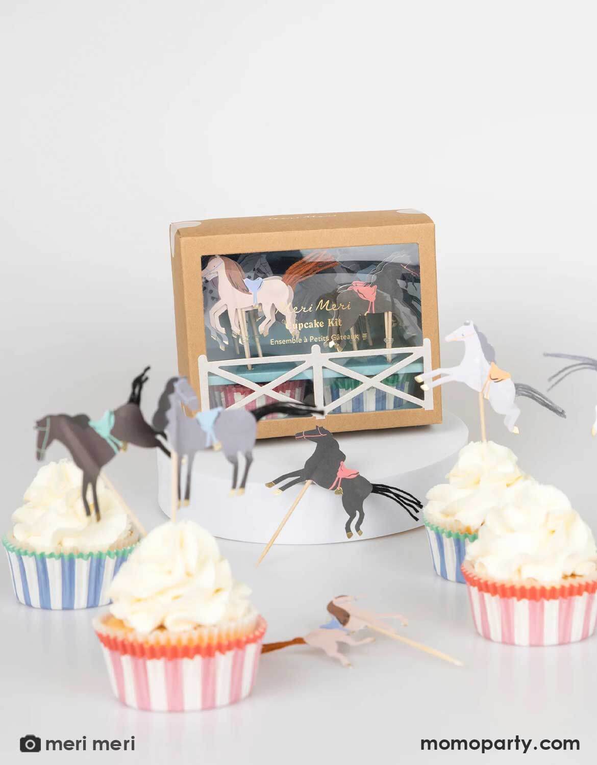 Cupcakes topped with Momo Party's horse-themed toppers and striped wrappers by Meri Meri with the cupcake kit package in the back on a white background.