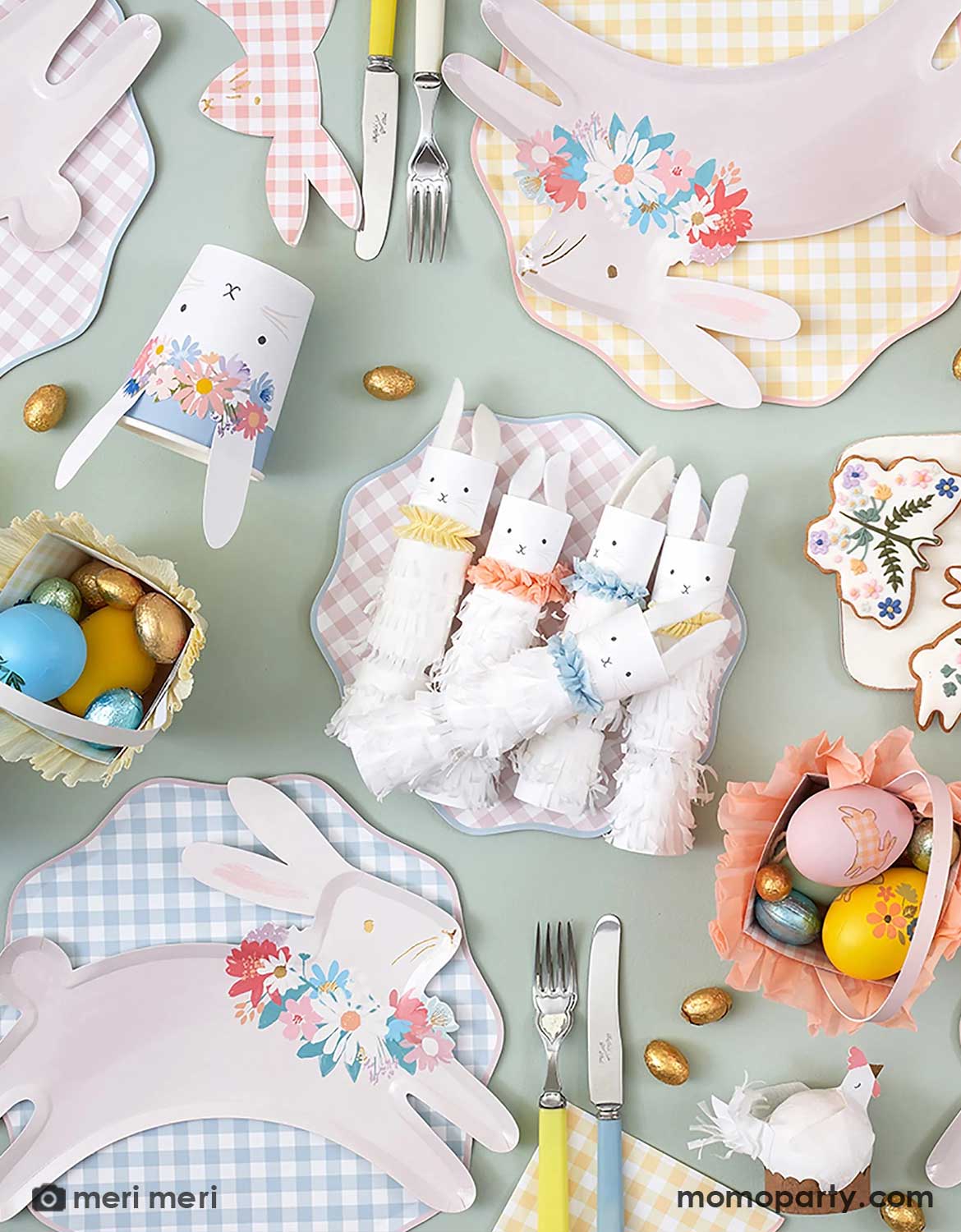 Easter-themed table setting with bunny cutouts, colorful eggs, and decorative plates on a light green background.