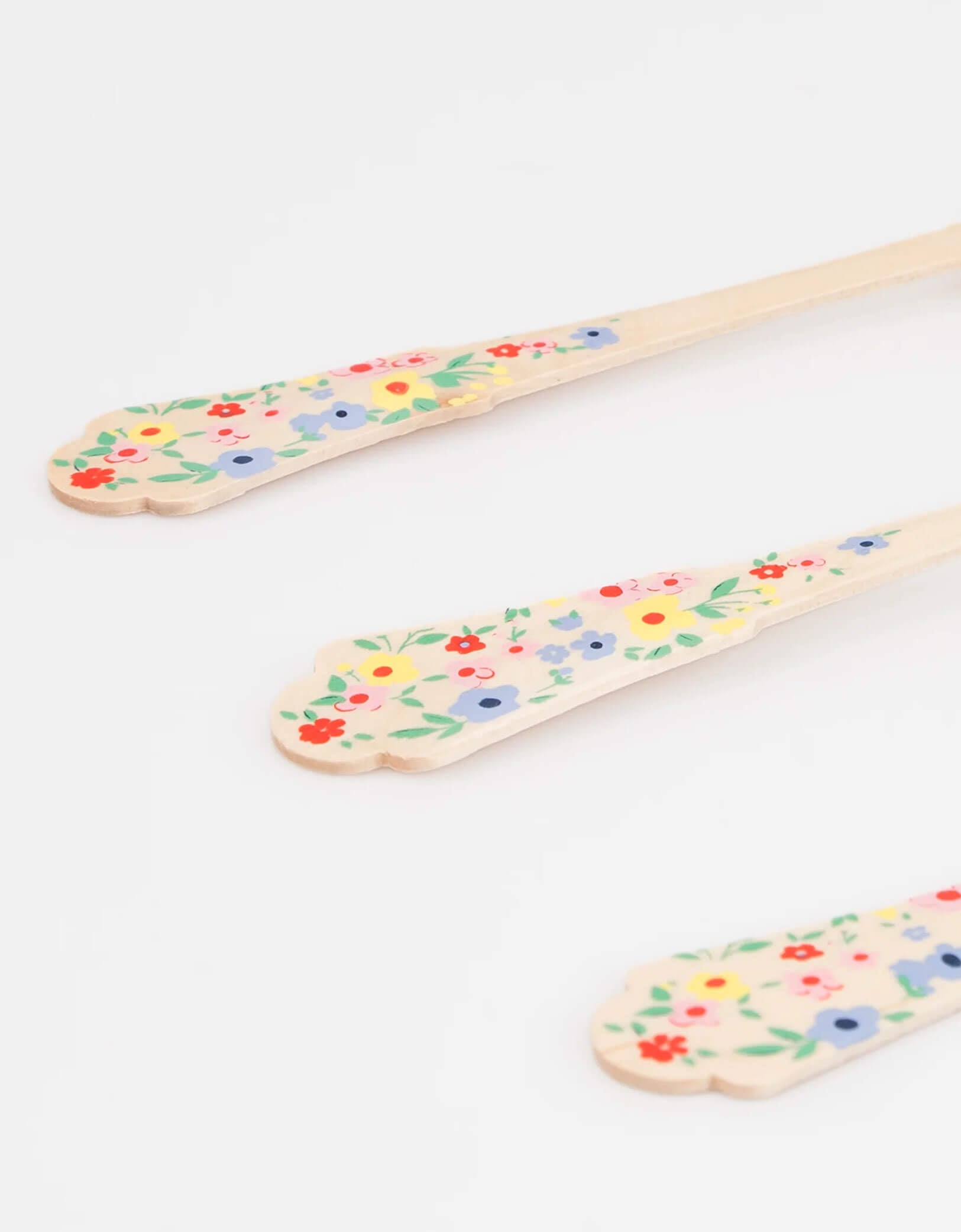 A close up shot of Momo Party's Elegant Floral Wooden Cutlery by Meri Meri. Comes in a set of 24, made of eco- friendly birchwood with sculpted handles, they are 100% biodegradable. This set features colorful floral handles for a fresh, summery look. Perfect for a garden party, Mother's Day celebration for a girl's tea party birthday celebration.