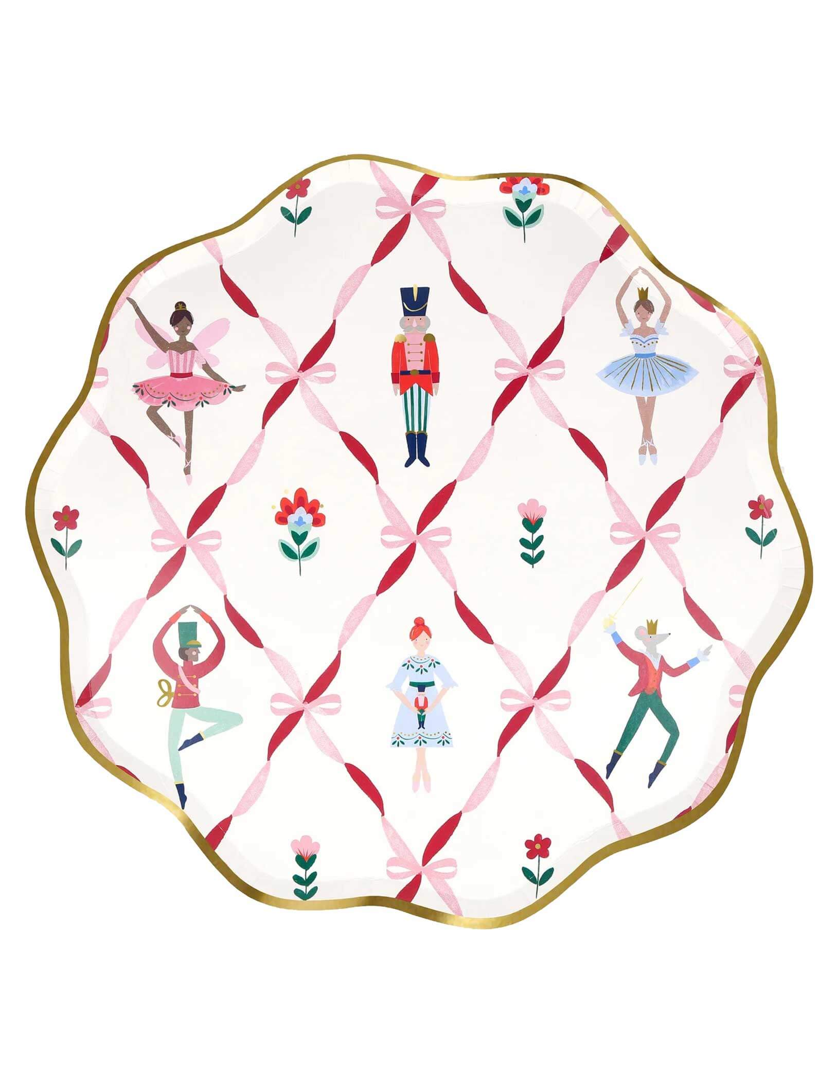 Momo Party's 10.5" Nutcracker ballet dinner plate with scallop edge in gold foil with the design of pink ribbon bows, sugarplum fairies, Nutcracker soldiers, the Mouse King, ballerinas on a white background.