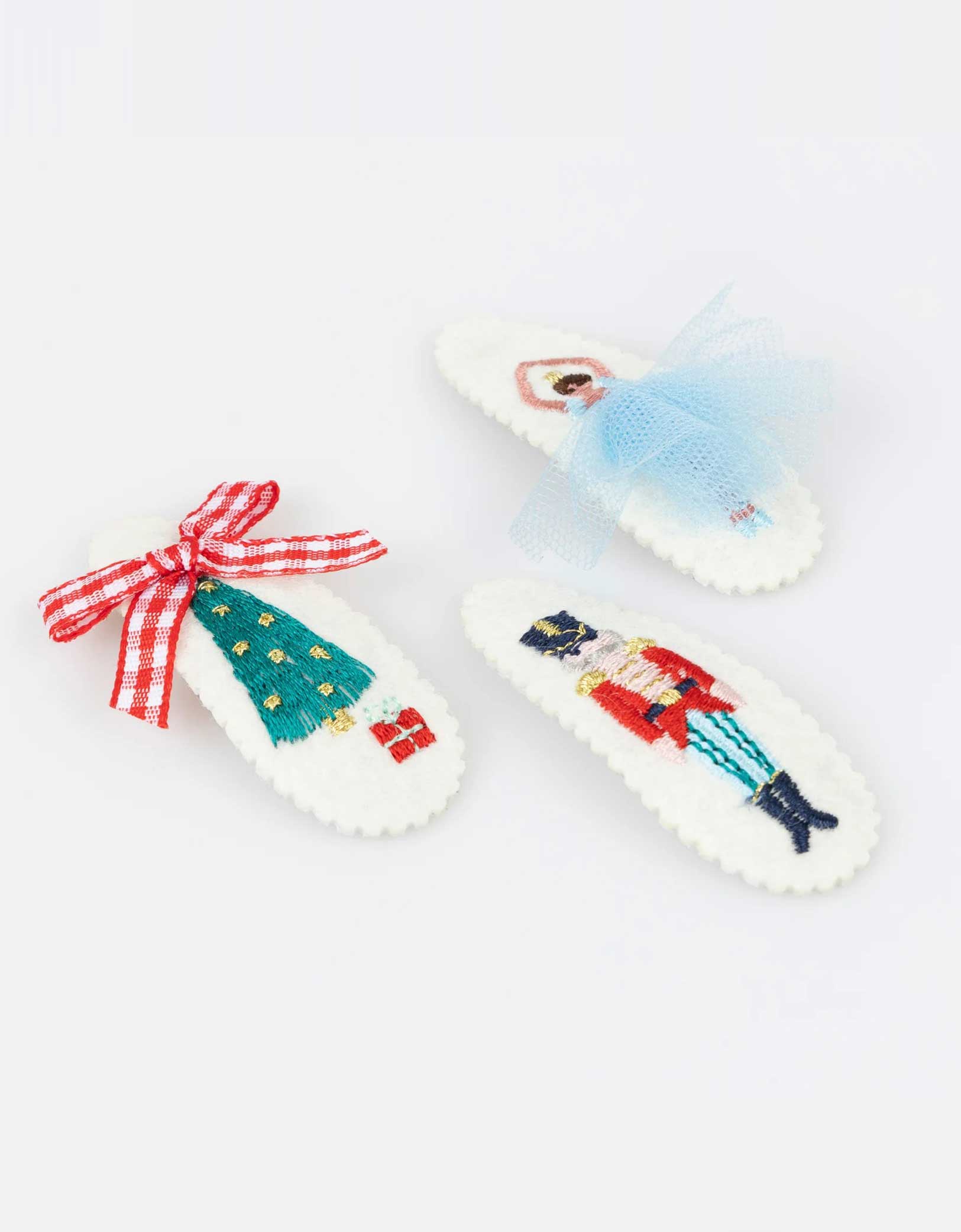 Momo Party's set of Nutcracker hair clips featuring iconic characters including a ballerina, Nutcracker soldier, and a Christmas tree in a chic mix of classic and modern festive colors by Meri Meri on a white background. A gorgeous gift or stocking filler for those who adore statement hair accessories.