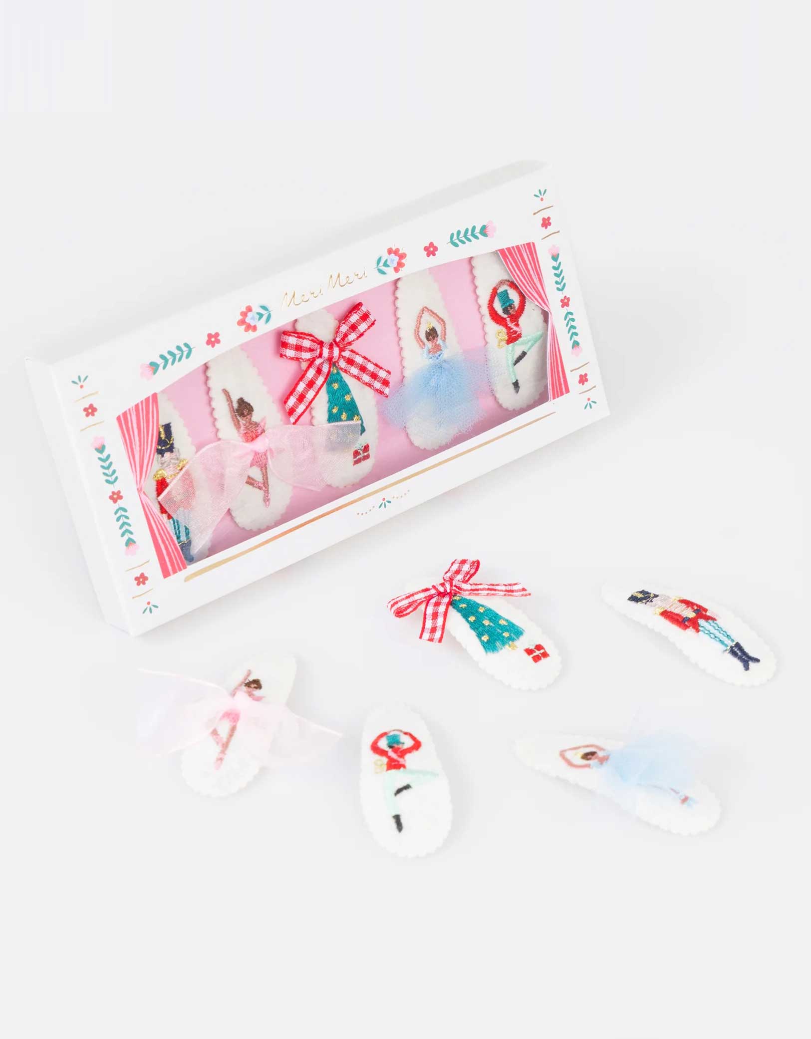 Momo Party's set of Nutcracker hair clips featuring iconic characters including ballerinas, Nutcracker soldier, Sugarplum fairy and Christmas tree in a chic mix of classic and modern festive colors with a decorative box by Meri Meri on a white background. A gorgeous gift or stocking filler for those who adore statement hair accessories.