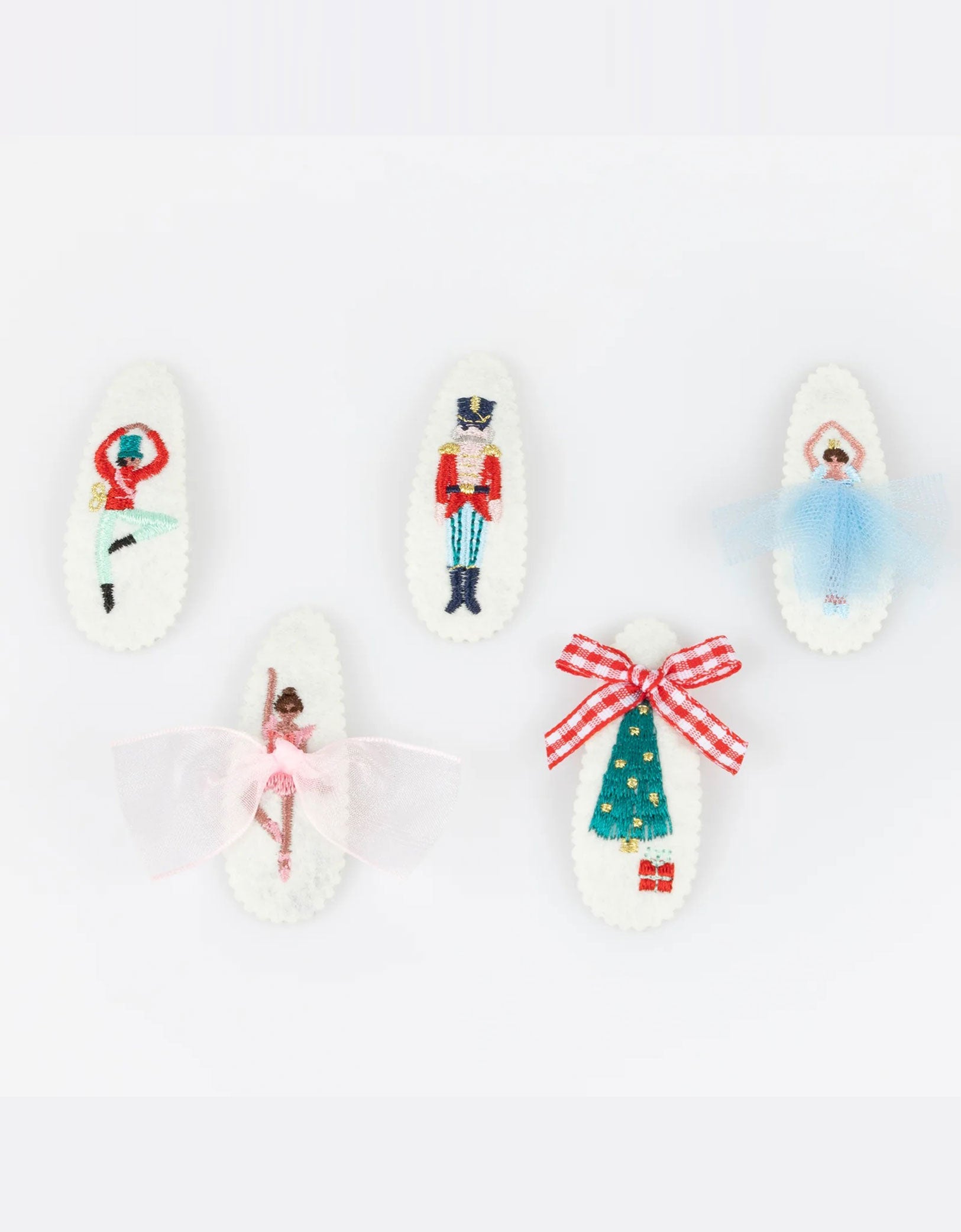 Momo Party's set of Nutcracker hair clips featuring iconic characters including ballerinas, Nutcracker soldier, Sugarplum fairy and Christmas tree in a chic mix of classic and modern festive colors by Meri Meri on a white background. A gorgeous gift or stocking filler for those who adore statement hair accessories.