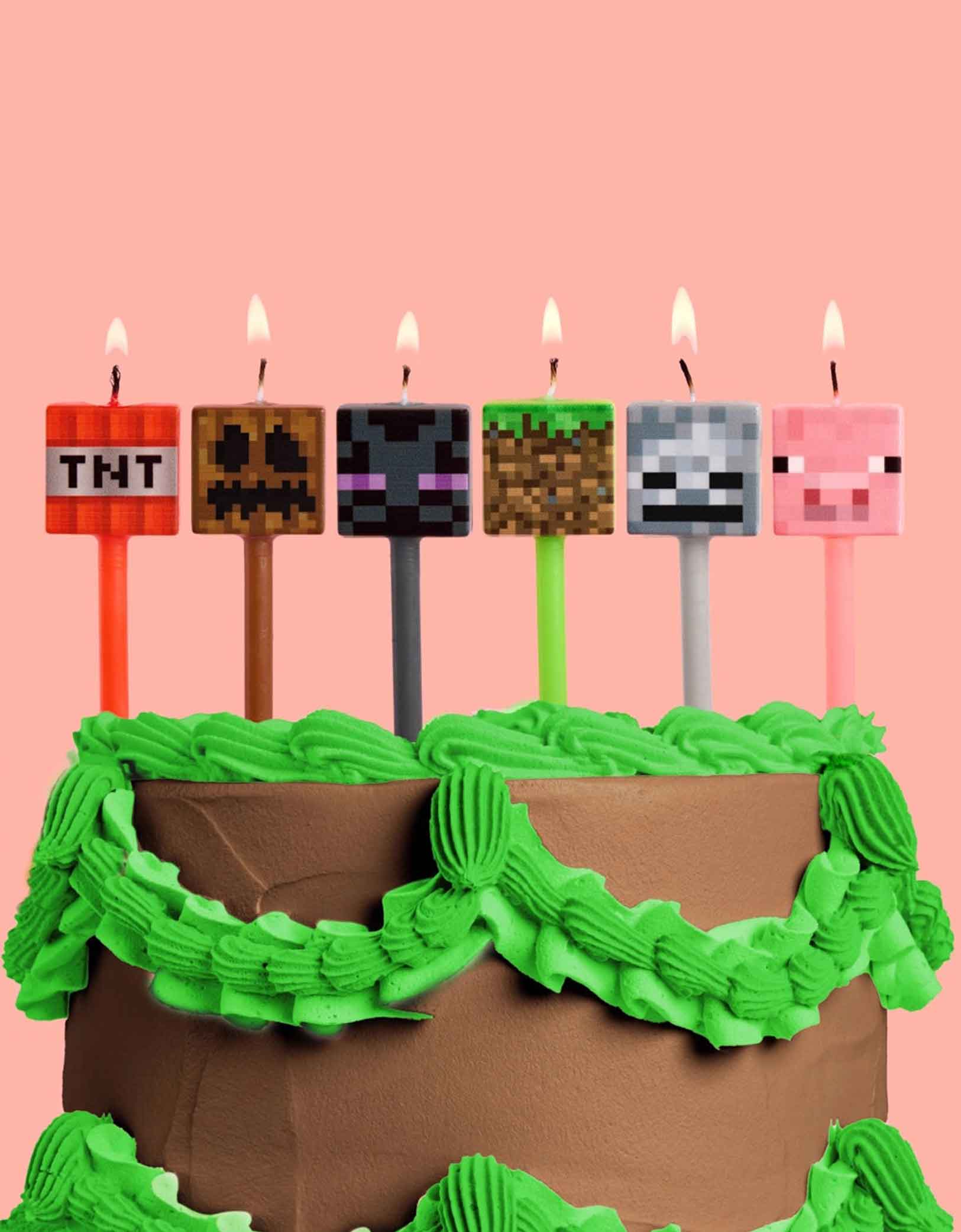 A Minecraft themed birthday cake with Momo Party's Pixel Minecraft Candles featuring TNT, pig face, Enderman and pixel faces on a pink background.