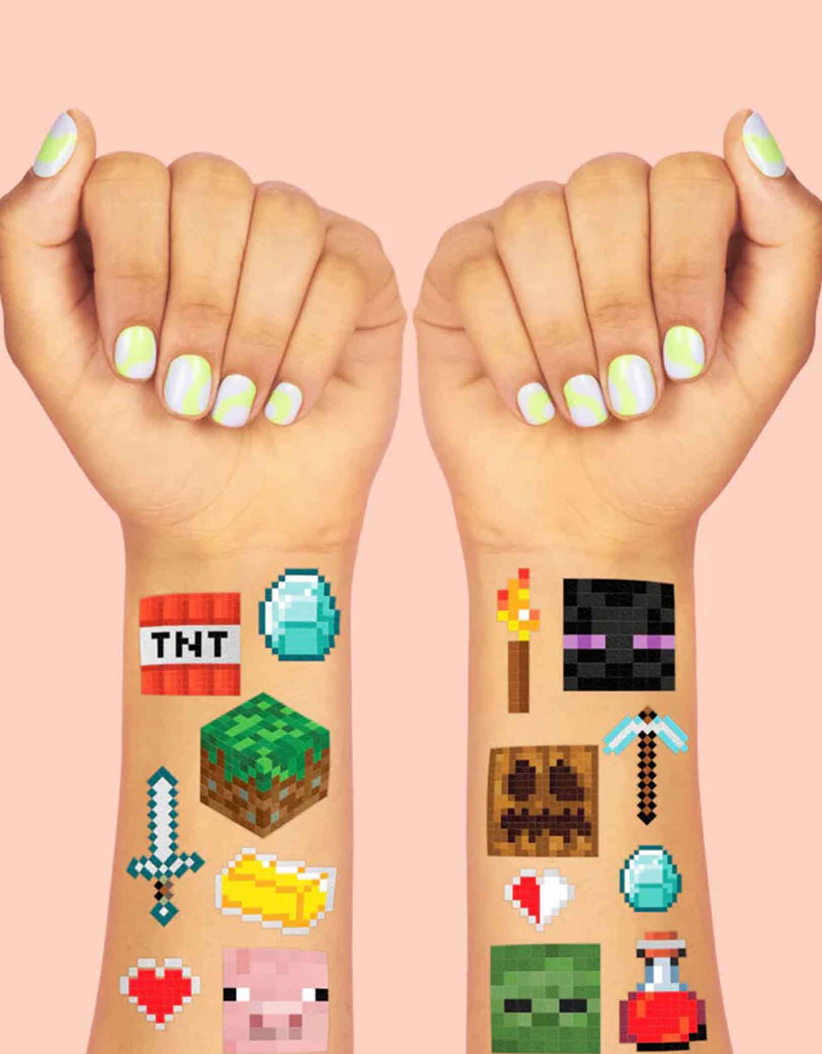 Two hands with Minecraft-themed temporary tattoos featuring pixelated block designs including TNT, creeper, pig, pixel axes, pixel swords etc. from Momo Party on a pink background.