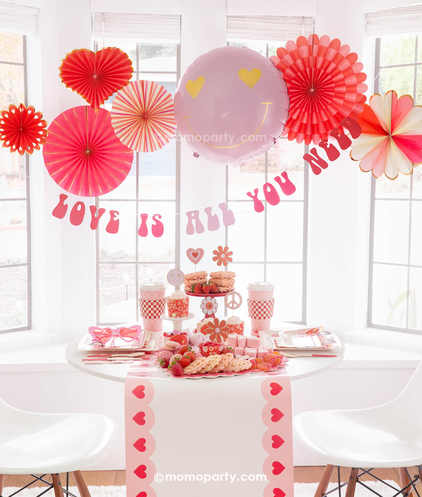 Momo Party presents the Groovy Valentine's Day Party Box, capturing a vintage vibe of love and peace with a groovy touch. This comprehensive kit includes My Mind's Eye Square Love Paper Plates, Luv Bus Paper Plates, All You Need is Love Napkins, Red Checks To-go Party Cups, Love Baking Cups With Toppers, Pink Heart Border Paper Table Runner, Heart You Paper Fan Set, Love Is All You Need Banner, and a Heart Eyes Love Foil Balloon. Perfect for throwing the ultimate Valentine's Day party