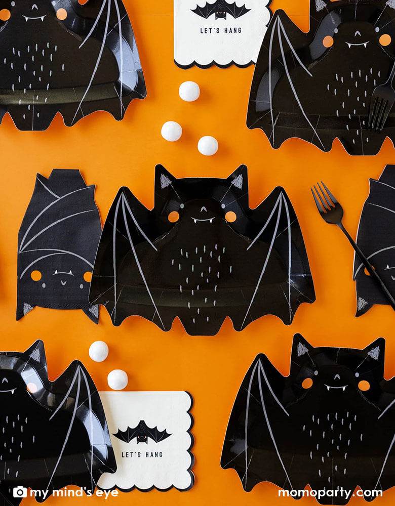 A classic Halloween black and orange table featuring Momo Party's 10.5" x 8.5" bat shaped plates, napkins and black square plates with white scalloped edge. Along the tableware, there are some black and white Halloween treats including candies, chocolates and gum balls, makes it a great party inspiration for kid's friendly Halloween party ideas.