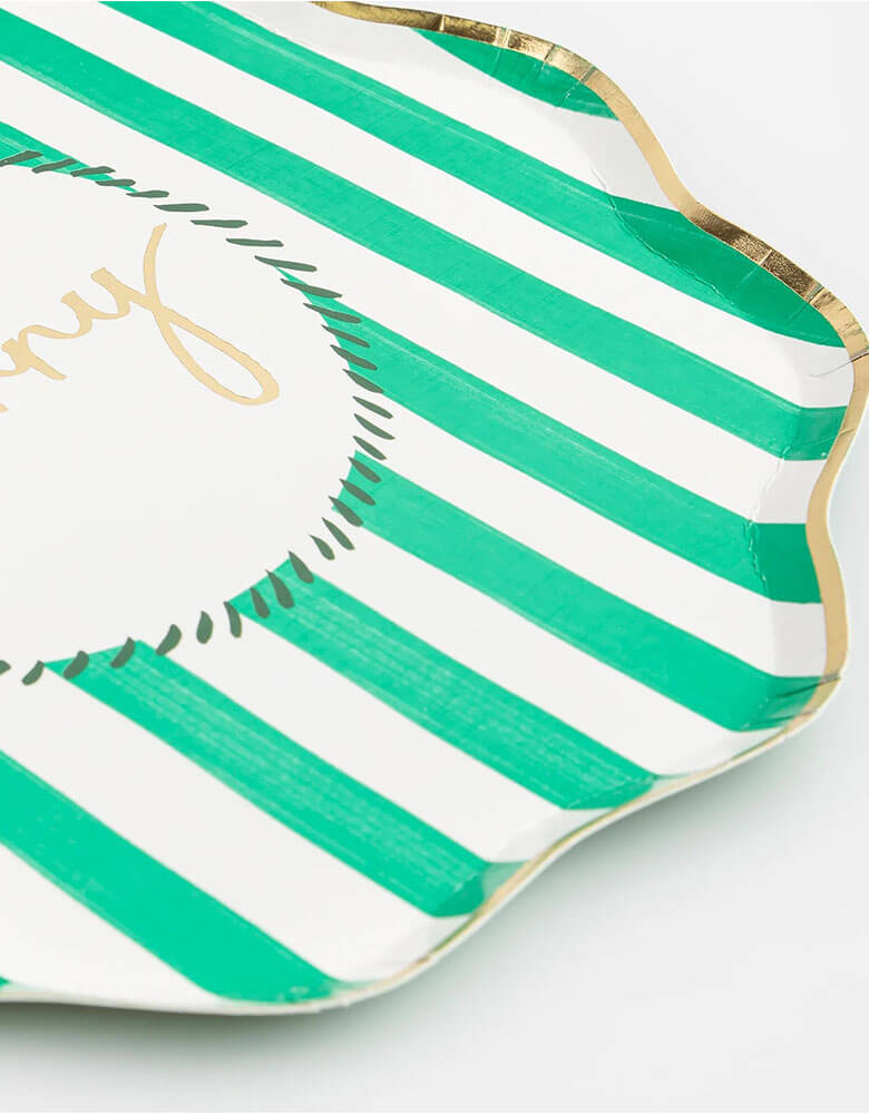 A close up at Momo Party's 10.25 x 10.25 inches Christmas striped dinner plates by Meri Meri. Come in a set of 8 in 4 different colors of red, pink, mint, and green with Jingle, Fa La LA, Merry, and Jolly words on them, these vintage inspired designs with gold foil details, with fun messages, will instantly add style to your celebrations over the holidays.