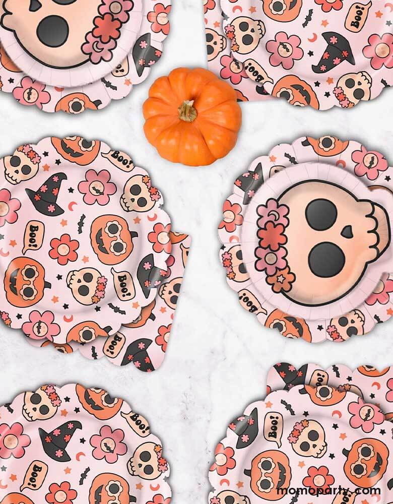 A fall Halloween party table featuring Momo Party's 8" Groovy Halloween Icon Plates, Floral skull plates and 6.5" Groovy Halloween Napkins by Ellie's Party. This collection is perfect for a cute and stylish Halloween table setting. Featuring groovy pumpkins, skulls, flowers, and witch hats, this party collection is great for a pink Halloween bash or kid's boho Halloween birthday party!