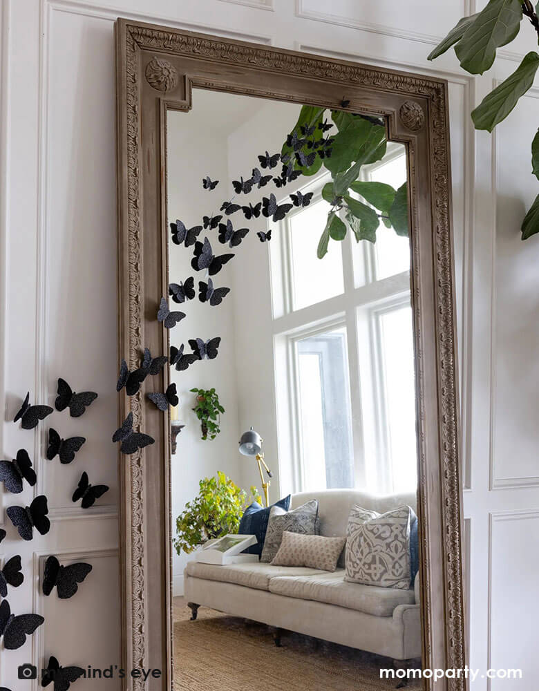 A large full body mirror decorated with Momo Party's Halloween Wall Black Glittered Butterflies Decorations by My Mind's Eye. These die cut and dimensional butterflies are the perfect way to add some fright to your home this Halloween.