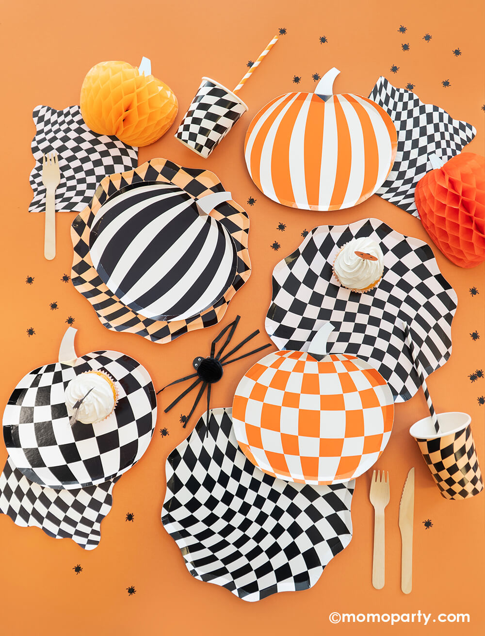 A classic Halloween orange and black party table by Momo Party featuring swirl checkered plates, napkins and cups by Meri Meri, along with mod and stripe patterned pumpkin shaped plates in black and orange. Makes it a classic Halloween look for a spooky fun Halloween bash!