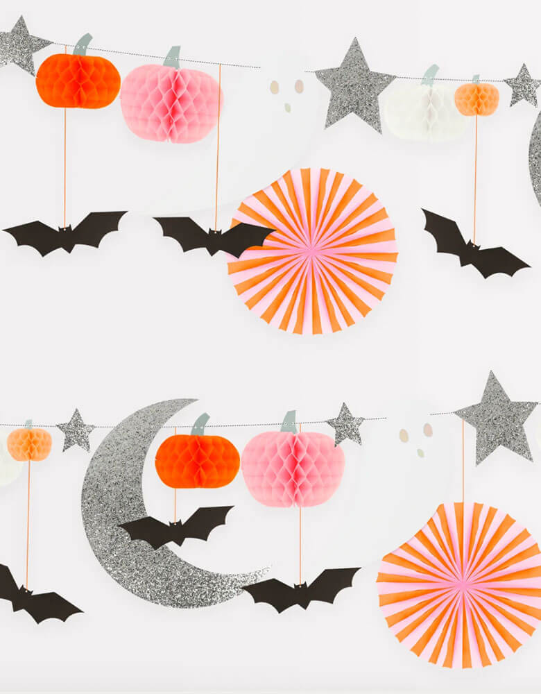 Momo Party's 7' Pastel Honeycomb Halloween Garland Set by Meri Meri. This garland set includes 2 Pink and orange honeycomb tissue paper pinwheels, with neon orange cord 8 Orange, white, peach and pale pink honeycomb tissue paper pumpkins 2 Ghosts with shiny silver holographic foil details 6 Black bats, with neon orange cord 8 Stars and a moon made from chunky silver glitter fabric. It's perfect for a pink Halloween themed party!