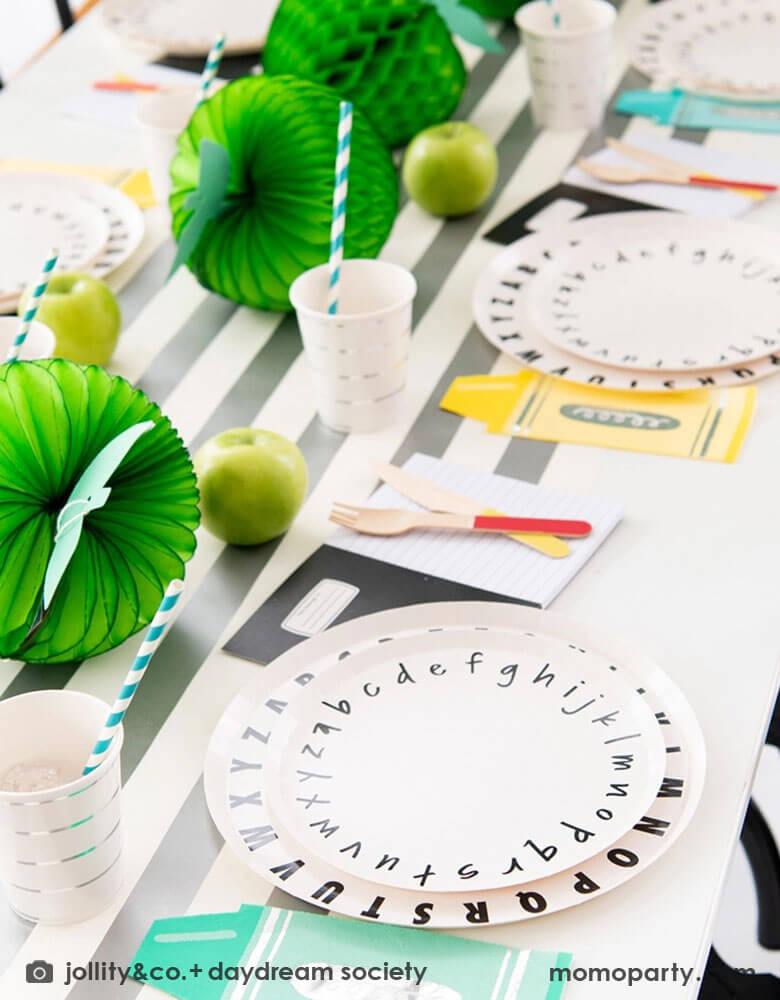 A back to school party table set up featuring Momo Party's School Days large and small Plates, along with crayon shaped napkins by Daydream Society. In the middle of the table were some lime green apple honeycombs and green balloons as the centerpiece. All in all makes a great inspiration of a school themed party or first day of school celebration!