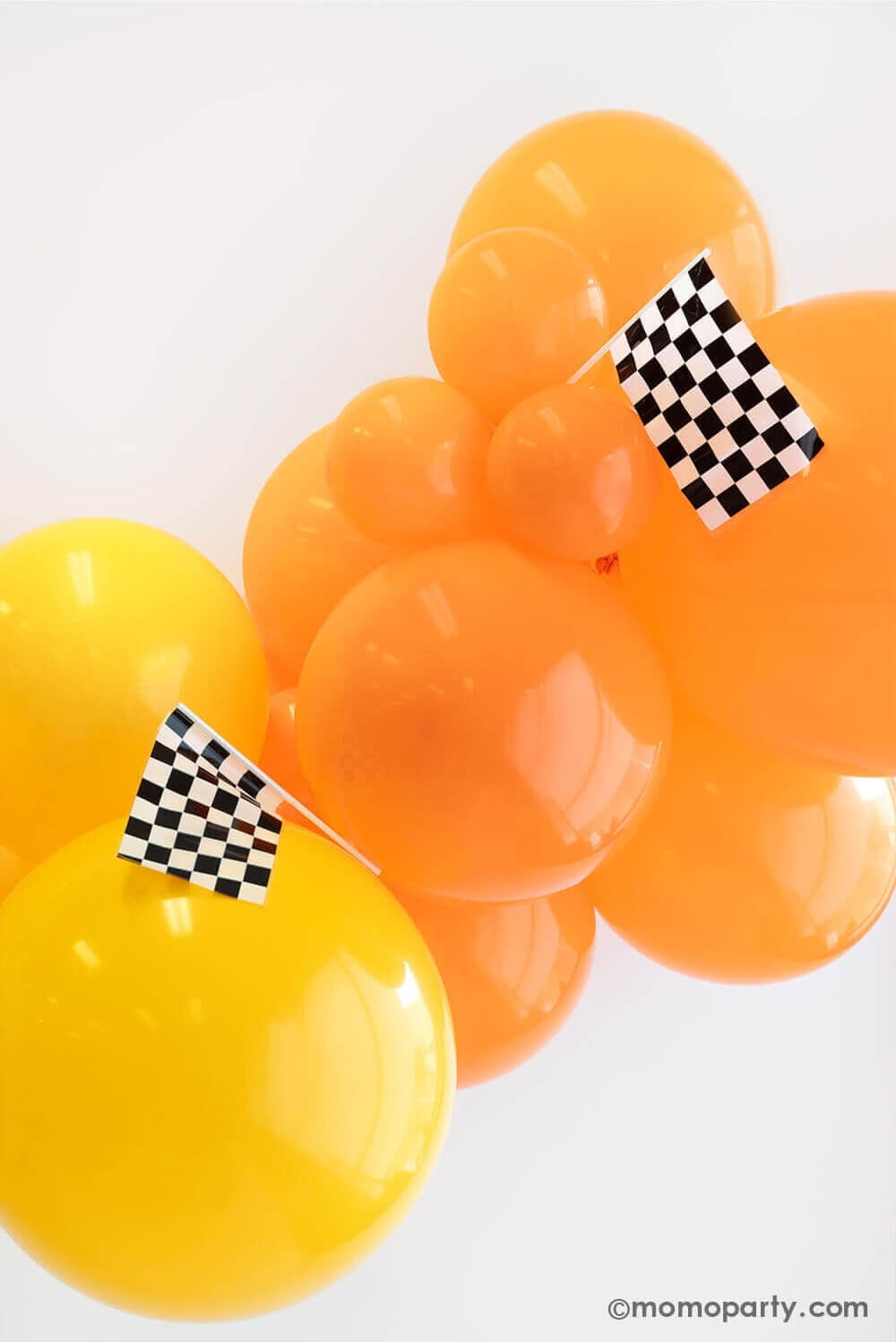Momo Party's Hot Wheels themed balloon garland with checkered flags for kid's race car themed birthday party.