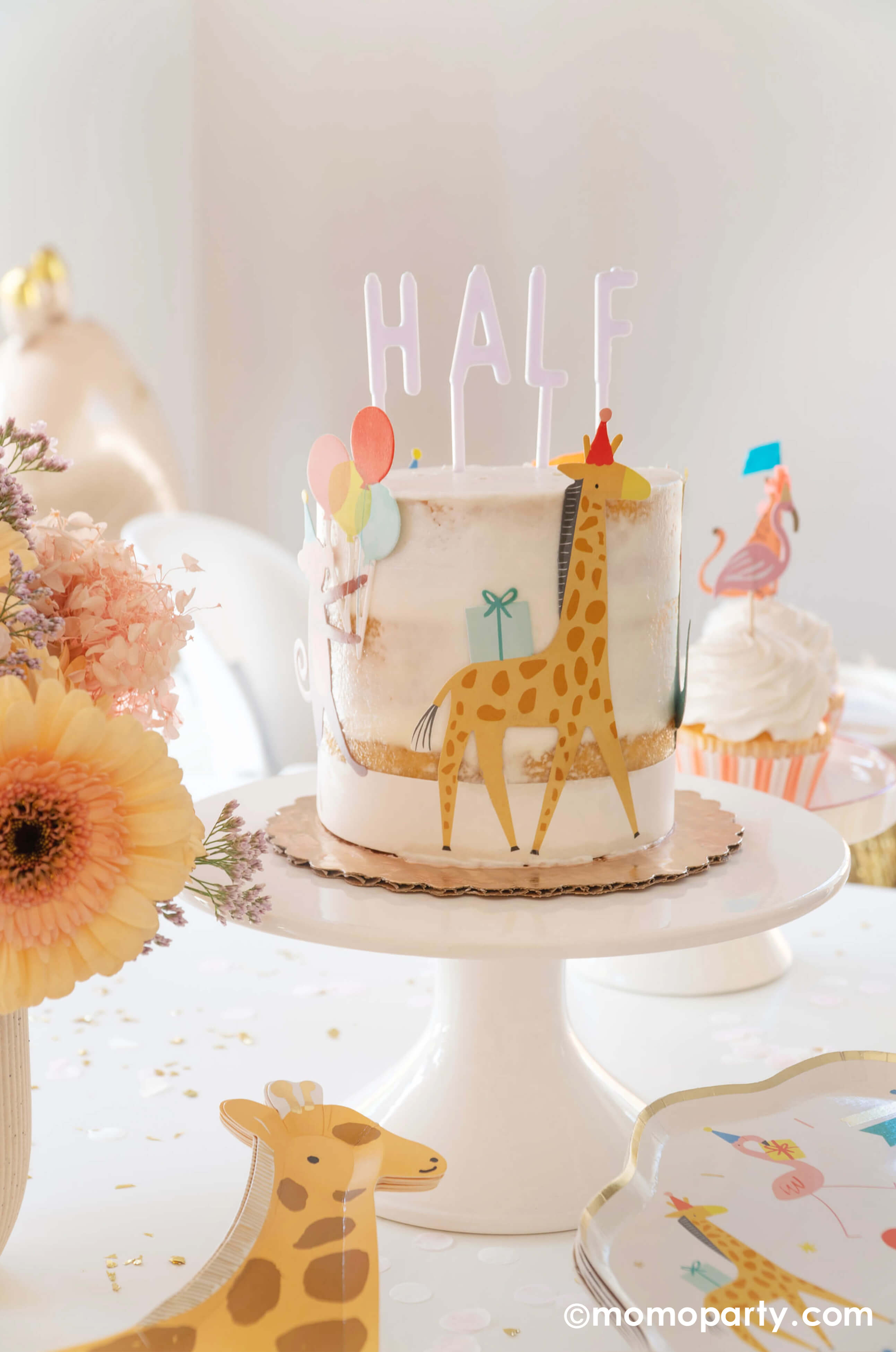 Momo Party hosted A kid's animal themed party table, with a Naked Cake decorated with Meri Meri Animal Parade Cake Wrap & Toppers, which featuring a giraffe with party hat, and on the top spelling "HALF"  with Cake By Courtney Letter-board Cake Toppers, repersend for a six months half birthday,  along with Meri Meri Animal Parade Dinner plate, Meri Meri giraffe shaped plates, fresh flower arrangement, it makes a great party inspiration for kid's animal, safari, carnival themed birthday party.