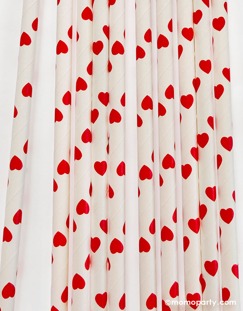 Details of momo Party's eco friendly disposable paper party straws with red hearts pattern on a white background.