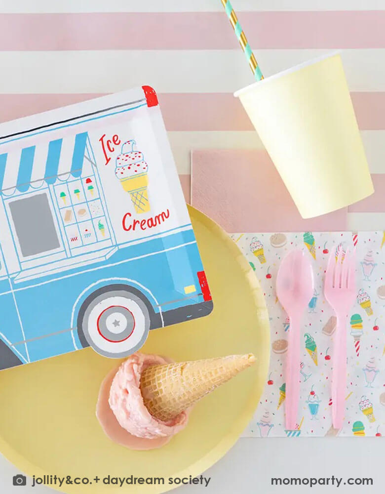 A festive party table featuring Momo Party's 10.5″ x 8″ Ice Cream Truck Plate by Daydream Society. Next to the ice cream truck plate there were a pink striped plate and napkin holding a scoop of ice cream in a waffle cone.