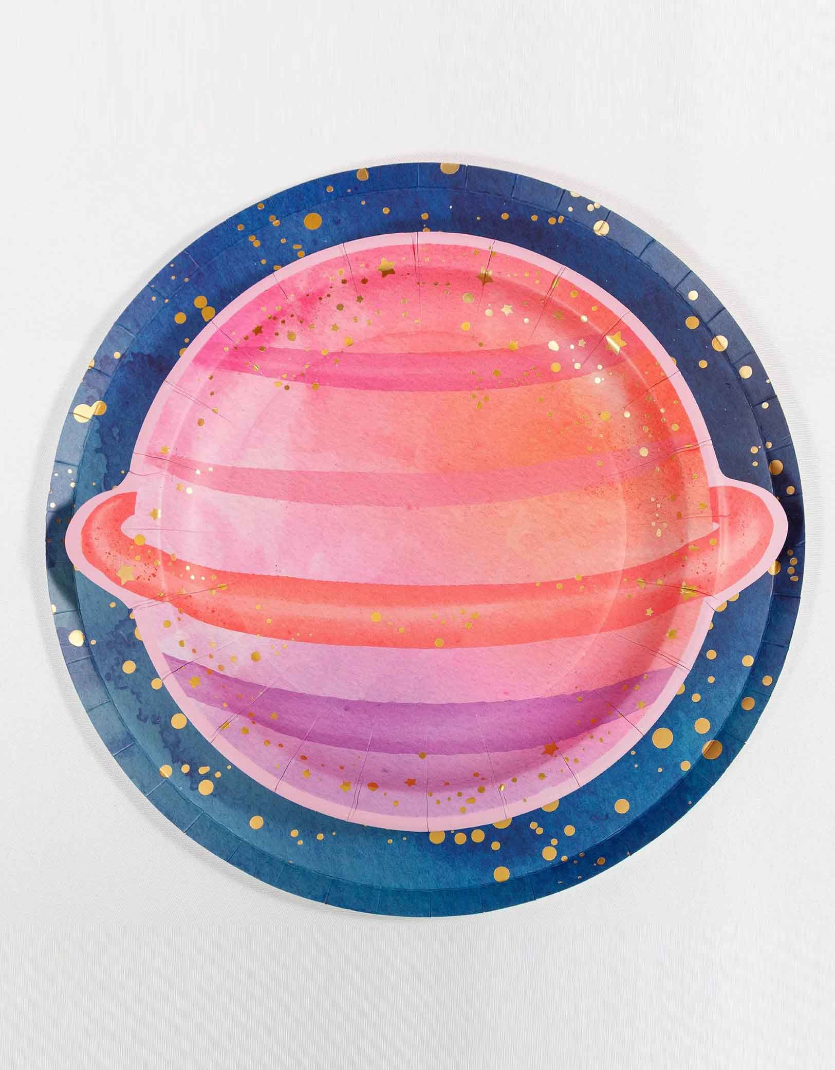 Momo Party's 8" pink planet shaped plate on top of the 10" blue galaxy round plate with old dots on it on a white background.