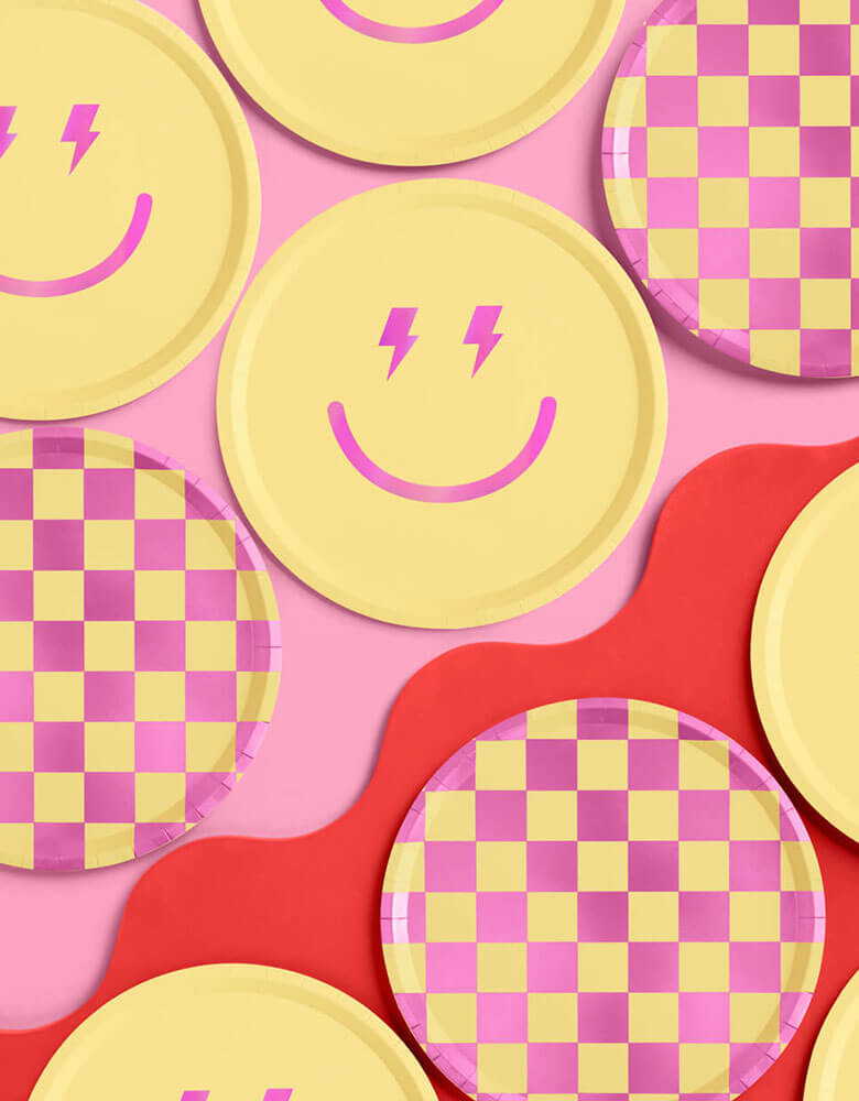 Momo Party's 9" Preppy Party Plates by Xo, fetti. Comes as 24 paper plates a set in two different colors/designs including yellow and pink checkers and a smiely face with lighting bolt eyes in pink, these groovy paper plates are perfect for a retro themed happy celebration.