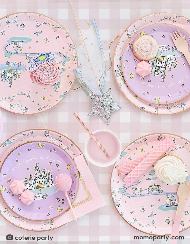 An adorable kid's princess table features Momo Party's 8.5' x 4.5' pink gingham tablecloth by Coterie. On the tablecloth there are some princess themed round paper plates with castles design on them, party cups and a glittered star wand. Making this a perfect inspo for a little girl's princess themed birthday celebration.