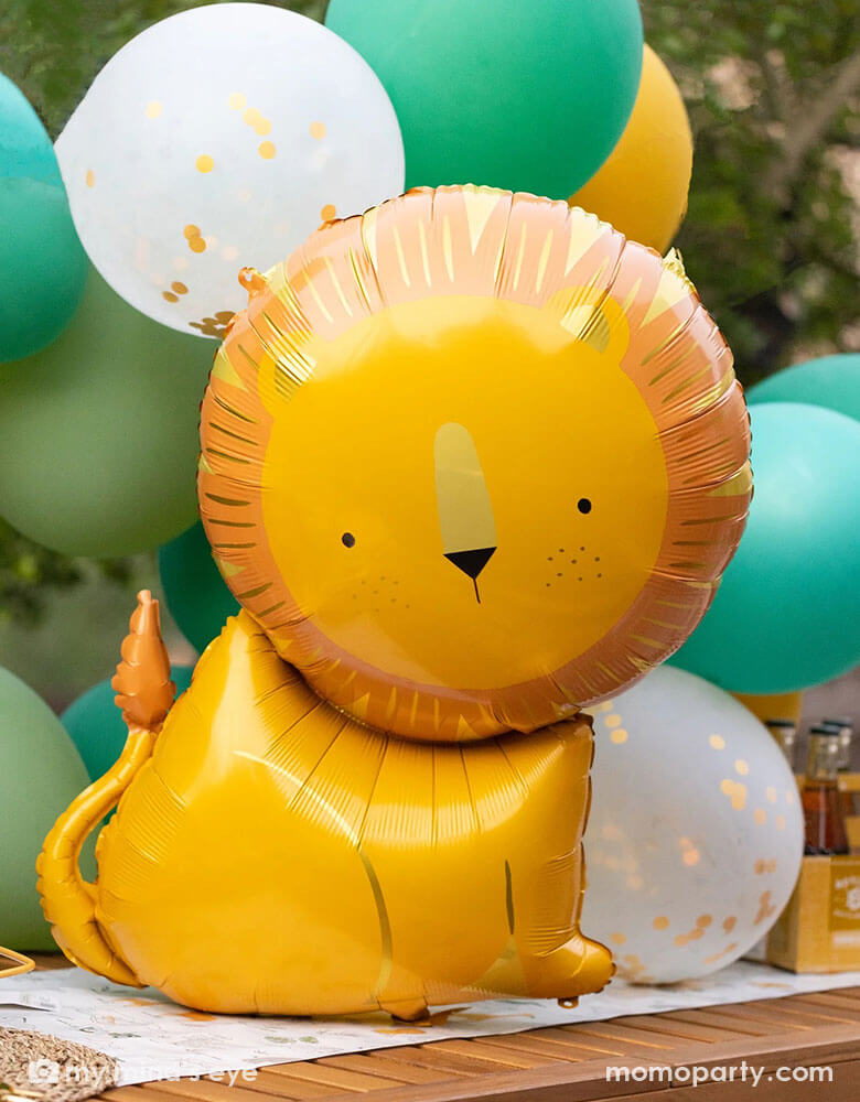 A kid's safari themed birthday party featuring Momo Party's 24" lion shaped foil mylar balloon by My Mind's Eye in front of a safari themed balloon garland. This charming lion shaped balloon adds the perfect amount of wild to a birthday celebration that will have your guests exclaiming "Oh My!" Perfect for kid's "Wild One" or "Two Wild" or "Young, wild and three" themed milestone birthday parties!
