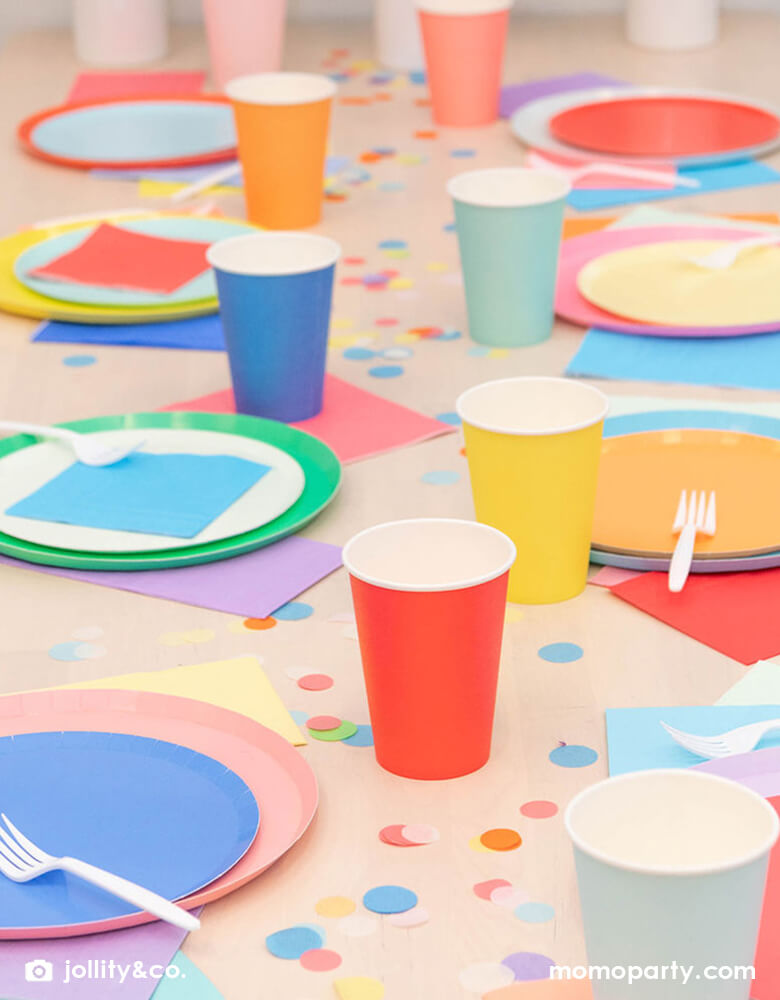 A Mix and match rainbow party table, decorated with rounded plates, colorful napkins, cups from Jollity The Shade Collection, colorful confetti, These partywares Featuring delicate low profile rim with a flat base, it’s perfect for mix and match for everyday celebration occasions!