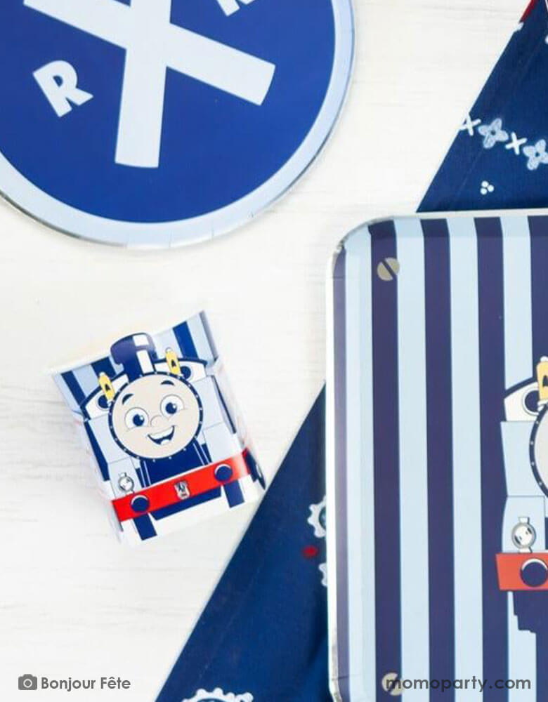 A kid's train themed birthday party table with Momo Party's Thomas and Friends party supplies including the 3D party cups, train railroad round blue side plates, and Thomas & Friends blue striped dinner plates. A perfect combination for your toddler's choo choo train themed celebration!