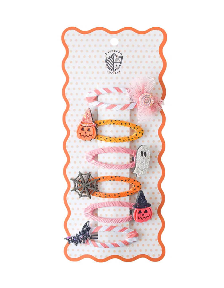 Momo Party's set of Halloween-themed hair clips with designs of a ghost, candy, pumpkin, spider web, bat in pink and peach designs on a Daydream Society card on a white background.