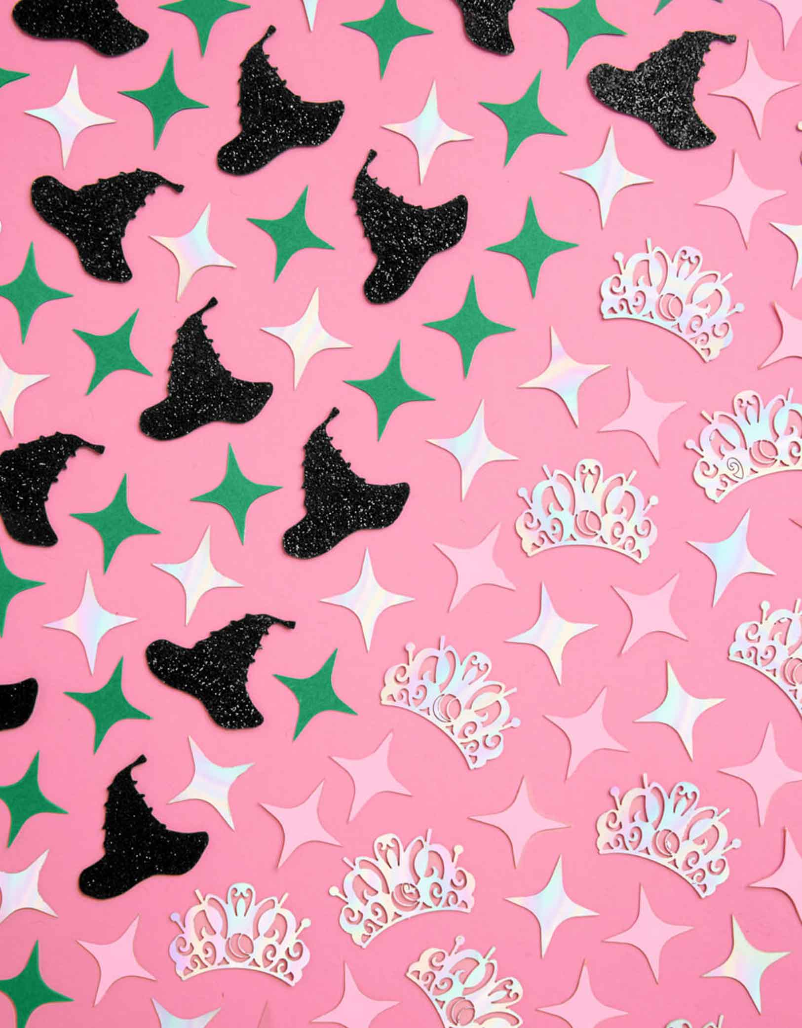 Momo Party's Wicked Witch Confetti featuring witch hats, tiaras, and stars on a pink background. This playful mix features tiny witch hats, sparkling tiaras, and bursts of pink and green confetti, perfect for casting a fun, wickedly charming spell over any party. Sprinkle it on tables or toss it in the air to enchant your guests with a festive, colorful vibe. Perfect for kid's Wicked birthday party, Halloween witch themed bash or a magical gathering.