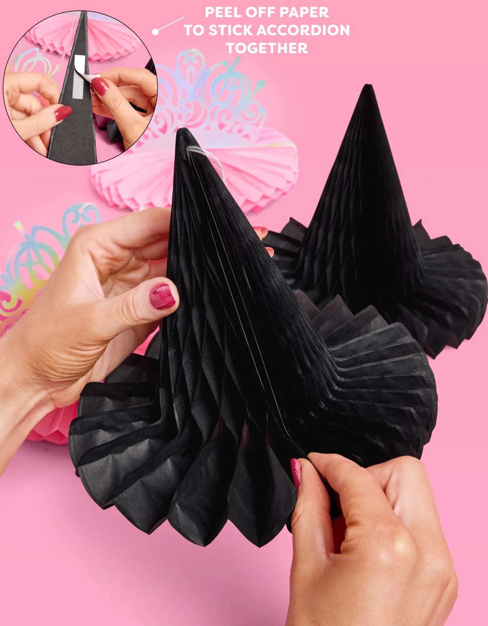 Momo Party's Wicked party black witch hat accordion-style honeycombs being assembled with text on a pink background.